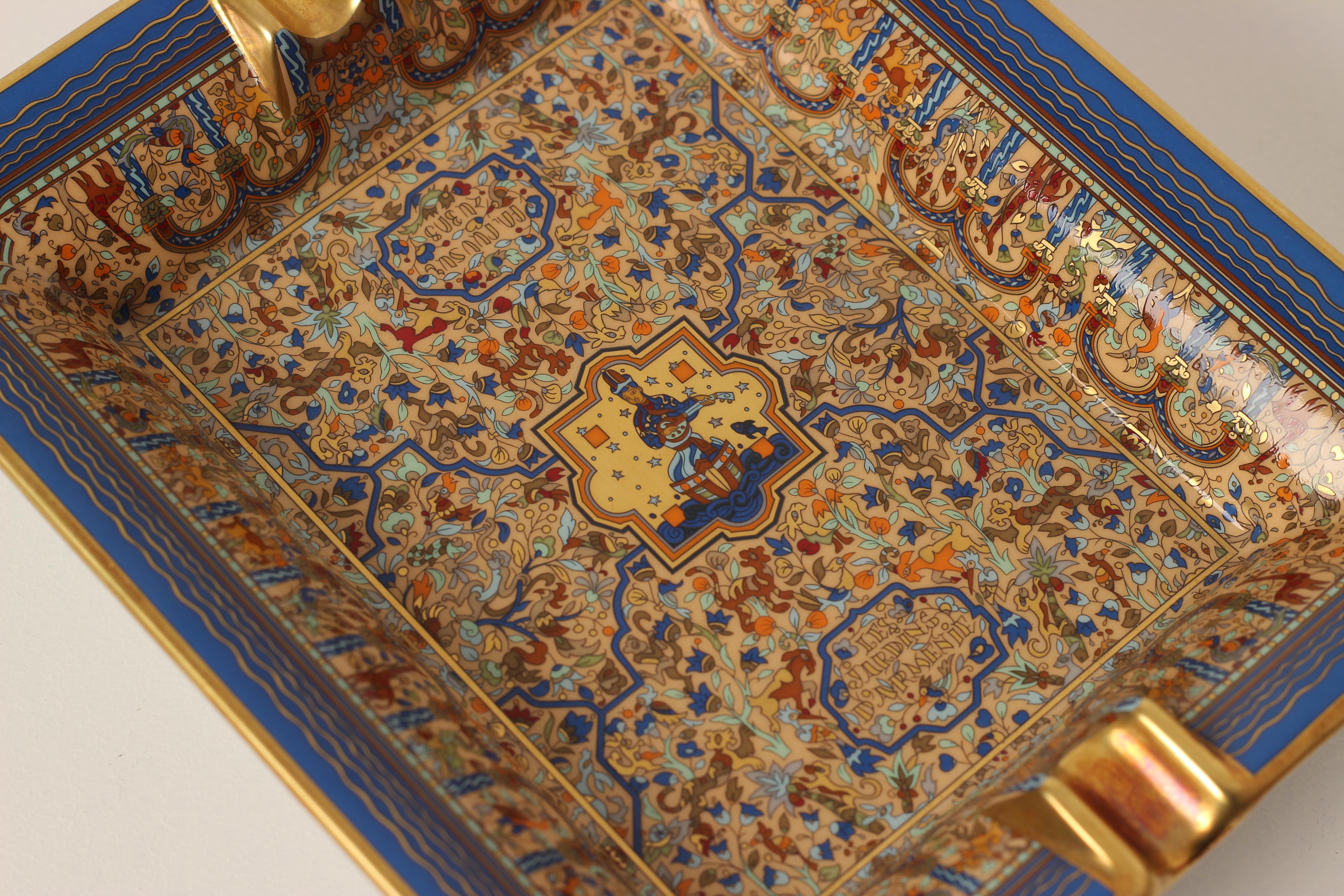 A Hermes porcelain Les Jardins d'Armenie ashtray or Vide-Poche catchall. 

Depicting an exotic Armenian garden intricately details and displayed in blue and gold border. Protected by velvet goatskin on the base, which would sit well on any