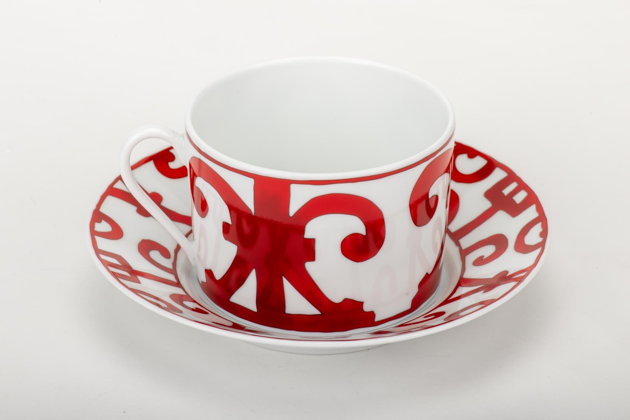 Hermès teacup and saucer with an ornate design in red and white. Brand new with box.