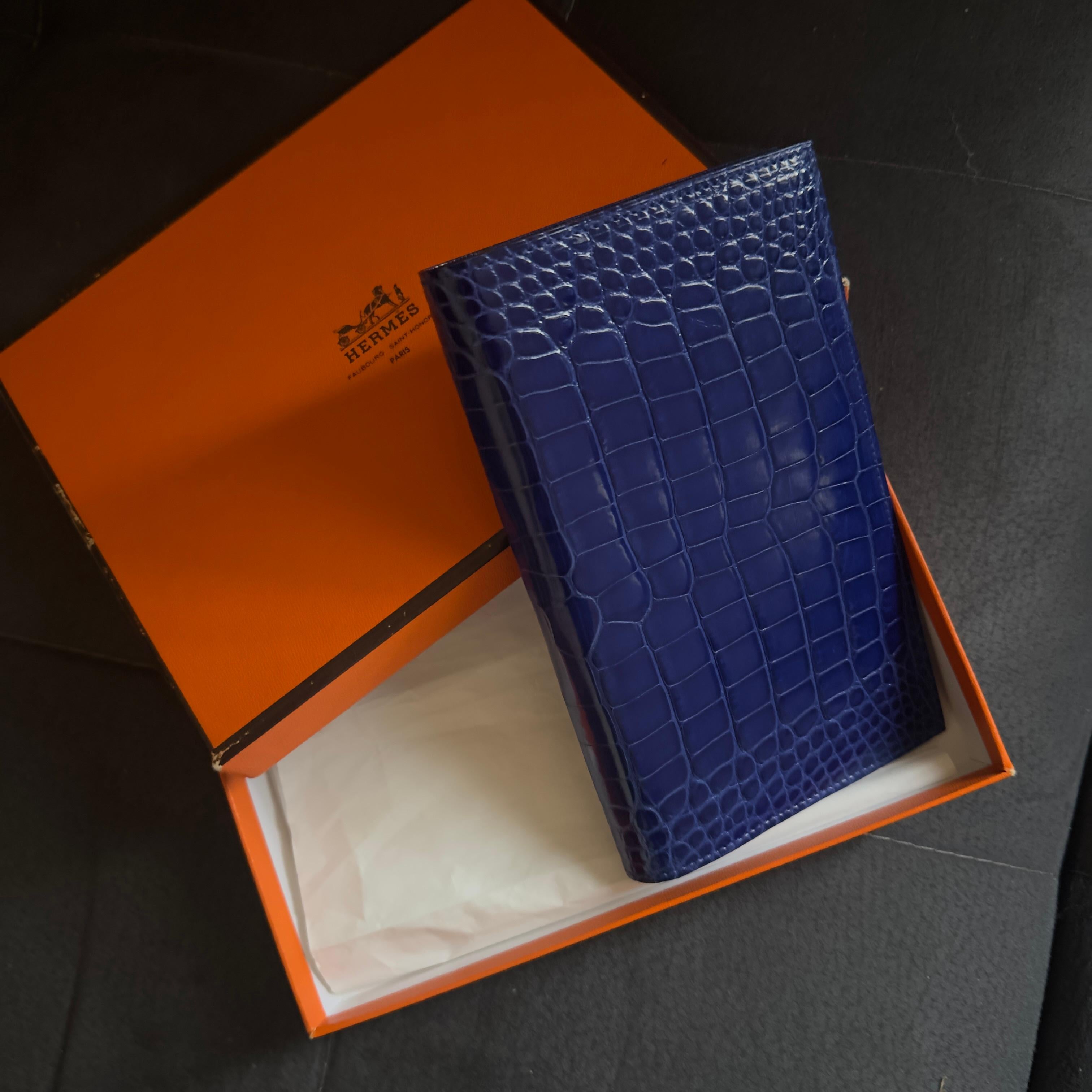 A refined Hermès agenda holder in precious shiny Bleu Saphir alligator, one of the Maison's most sought-after and sophisticated shades.
New piece, never used, complete with original Hermès box and AM control card, details that confirm its
