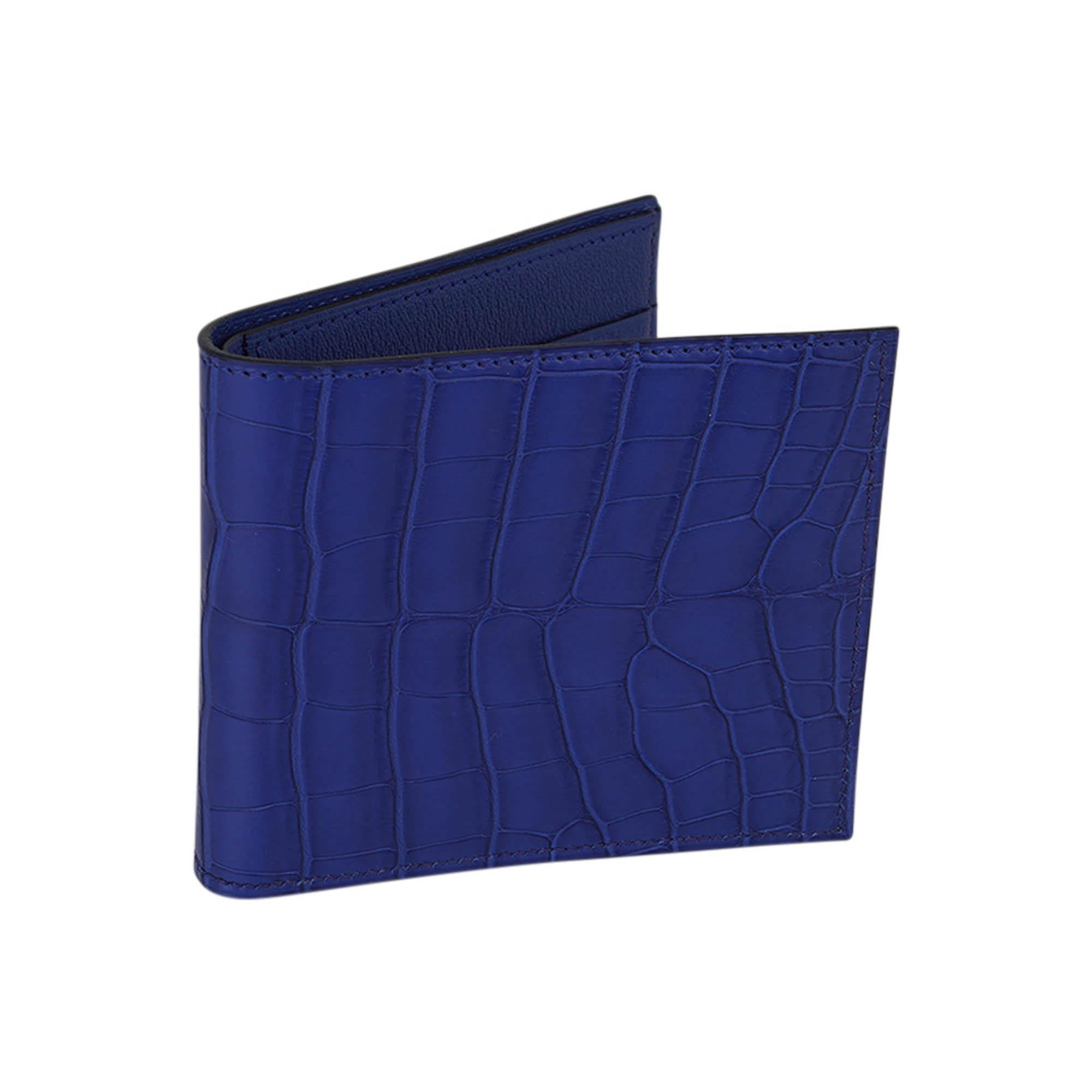 Mightychic offers an Hermes Men's MC2 Copernic compact bi-fold wallet featured in vibrant Bleu Saphir matte Alligator.
This Hermes men's wallet is rare to find, and is arguably one of the best wallets with clean sleek lines.
Interior is Chevre