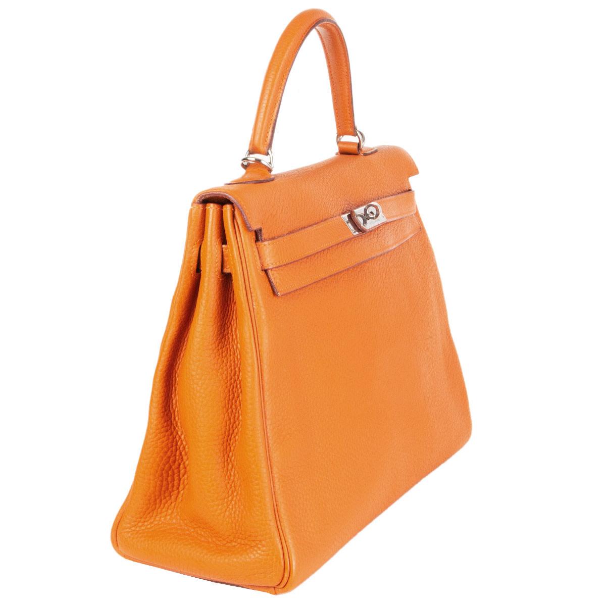 100% authentic Hermès 'Kelly 35 Retourne' bag in Portion (pumpkin orange) Taurillon Clemence leather with palladium hardware. Lined in Potiron goat skin leather with two open pockets against the front and a zipper pocket against the back. Has been