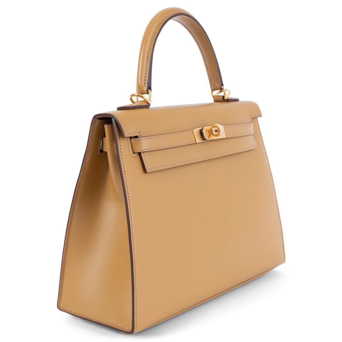100% authentic Hermès Kelly 25 Sellier bag in Poussiere (ocher brown) Veau Tadelakt leather with gold-plated hardware. Lined in Chevre (goat skin) with an open pocket against the front and a zipper pocket against the back. Brand new - Comes with