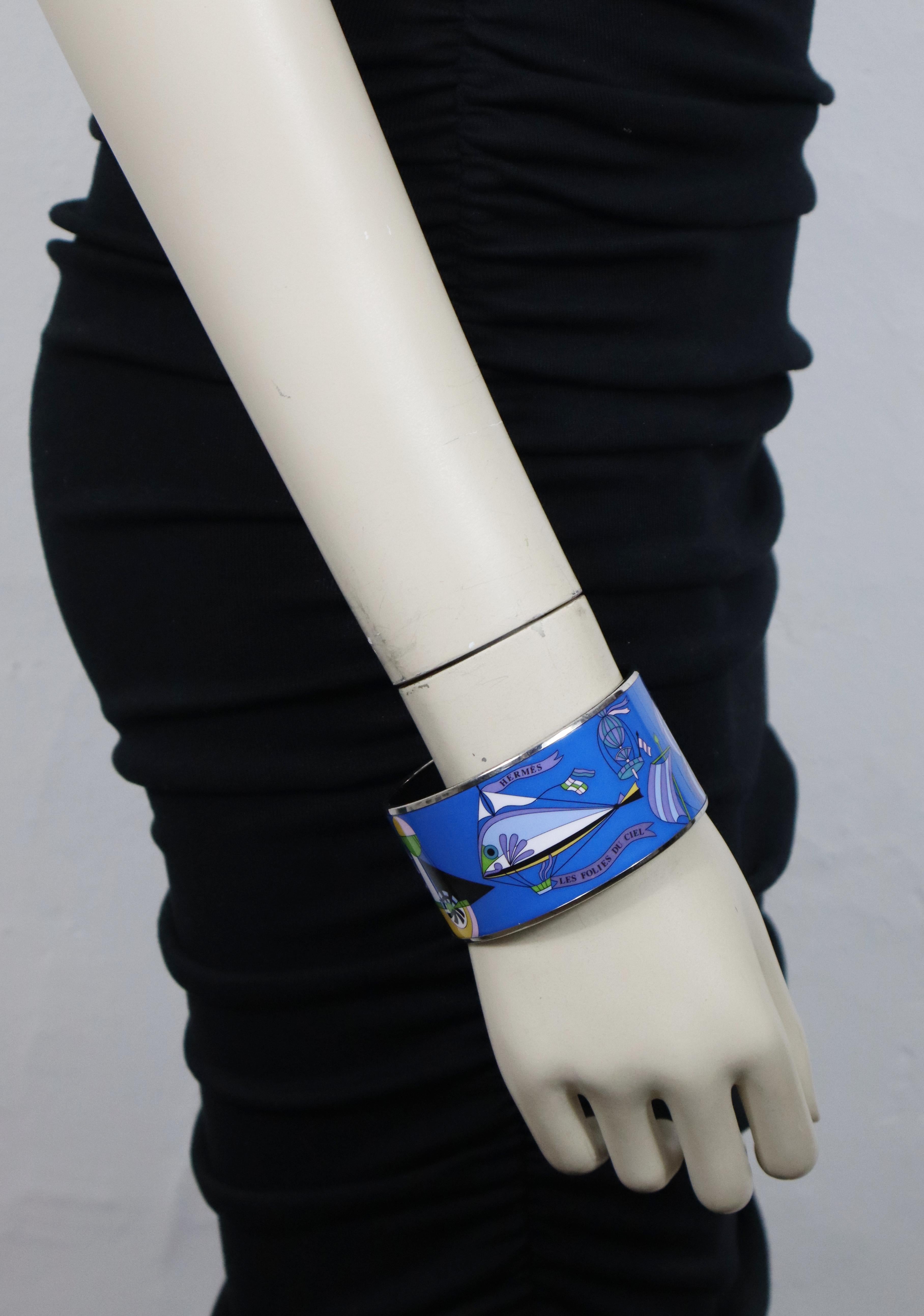 HERMES printed enamel cuff bracelet showcasing a multicolored Les Folies du Ciel motif with silver tone rims.

Marked HERMES Paris.
Made in Austria + I.
Private sale S mark engraved on the inner side of the bracelet (see the pictures / not visible