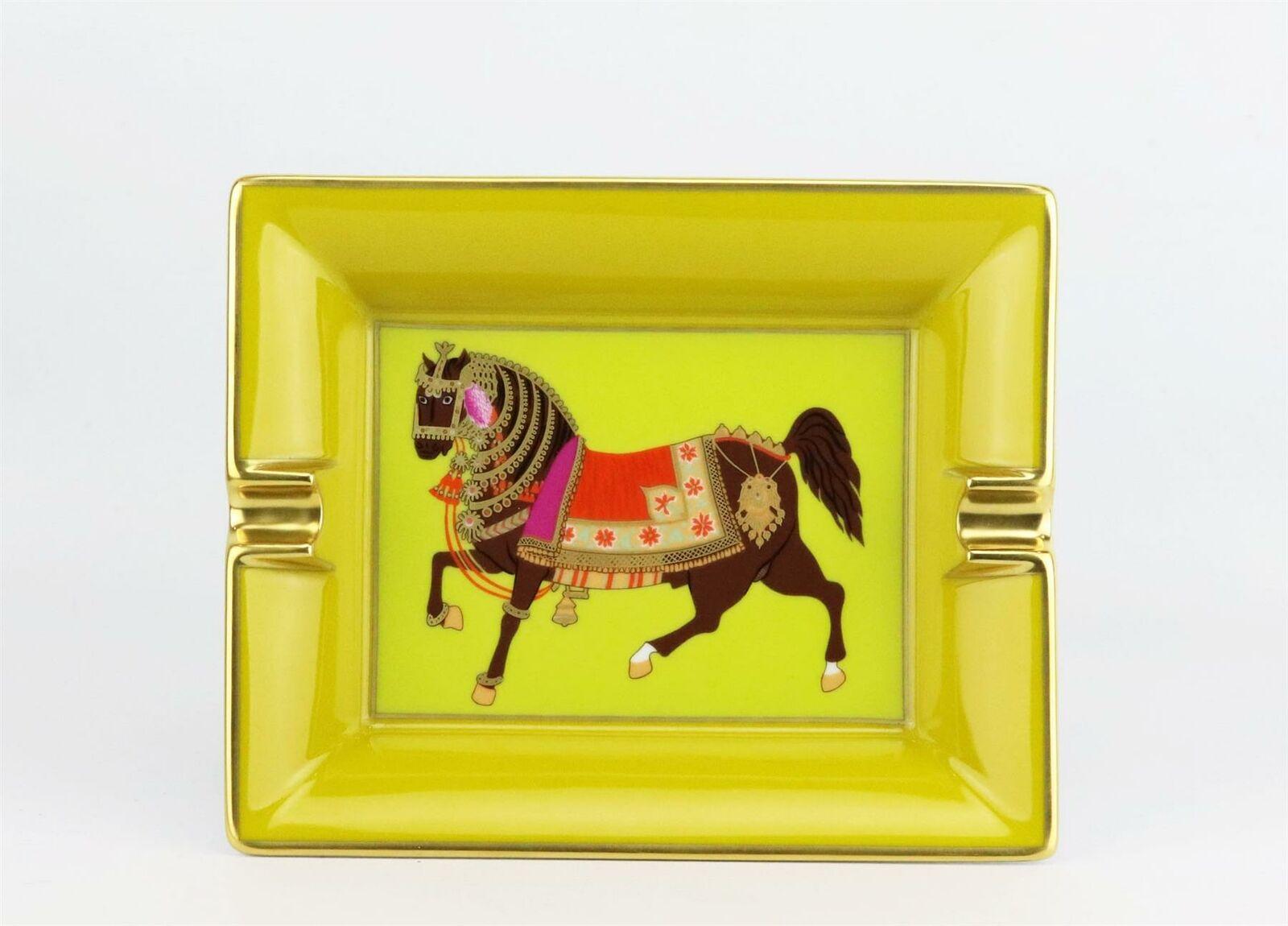 Mustard, lime-green and multi-coloured porcelain Hermès rectangular ashtray with horse accent on a green base centre, gilt trims and suede brand stamp underside.
Does not come with box.

Dimensions: L 7.75 x W 6.25 x D 1.6 inches

Condition: Used.