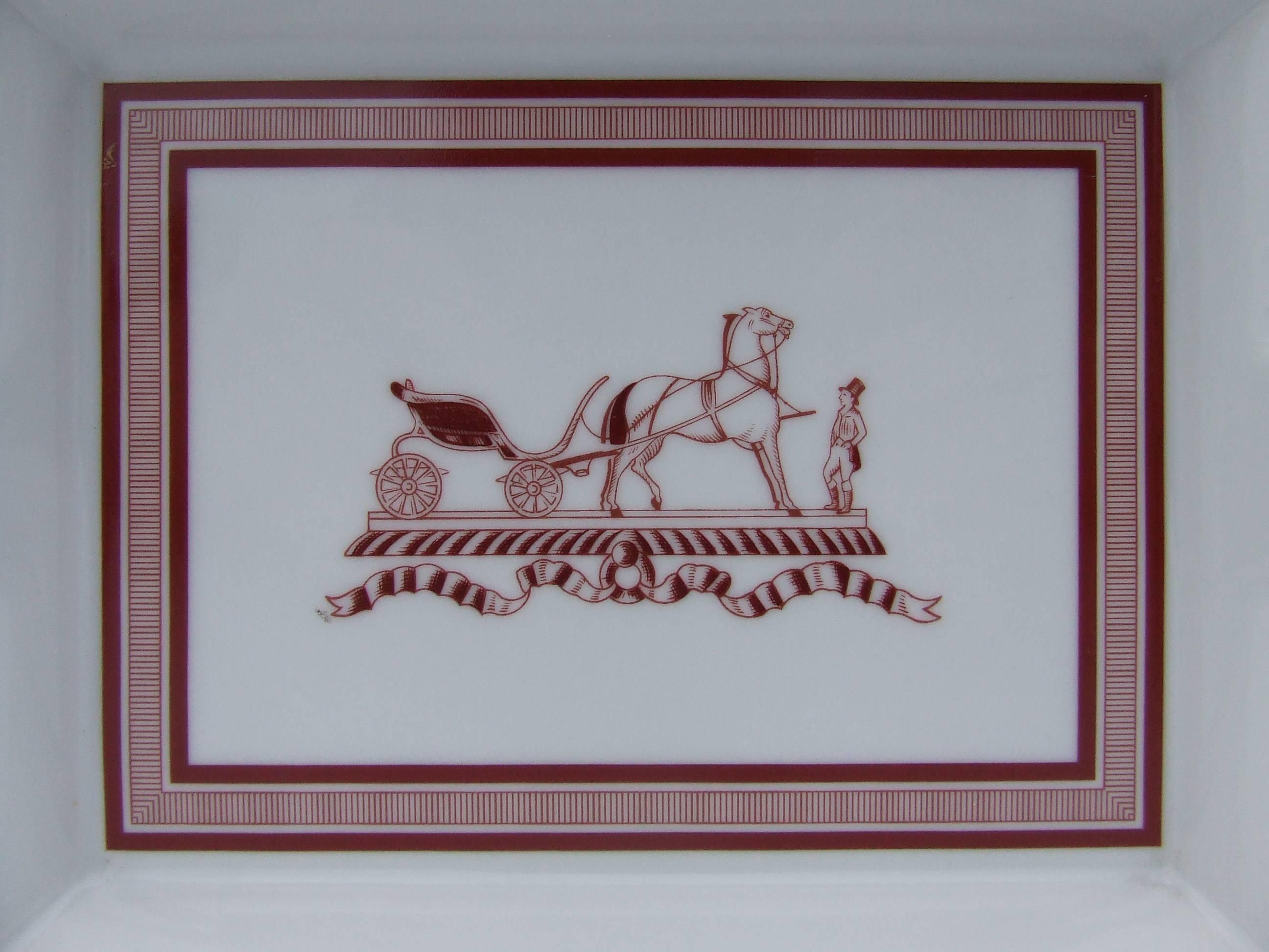 Beautiful Authentic Hermes Ashtray

Pattern: Hermès Traditional Logo of Carriage Horse and Coachman

Made in France

Made of Printed Limoges Porcelain

Colorways: White Background, Dark Red / Burgundy Drawings, Golden Edges

The bottom is covered