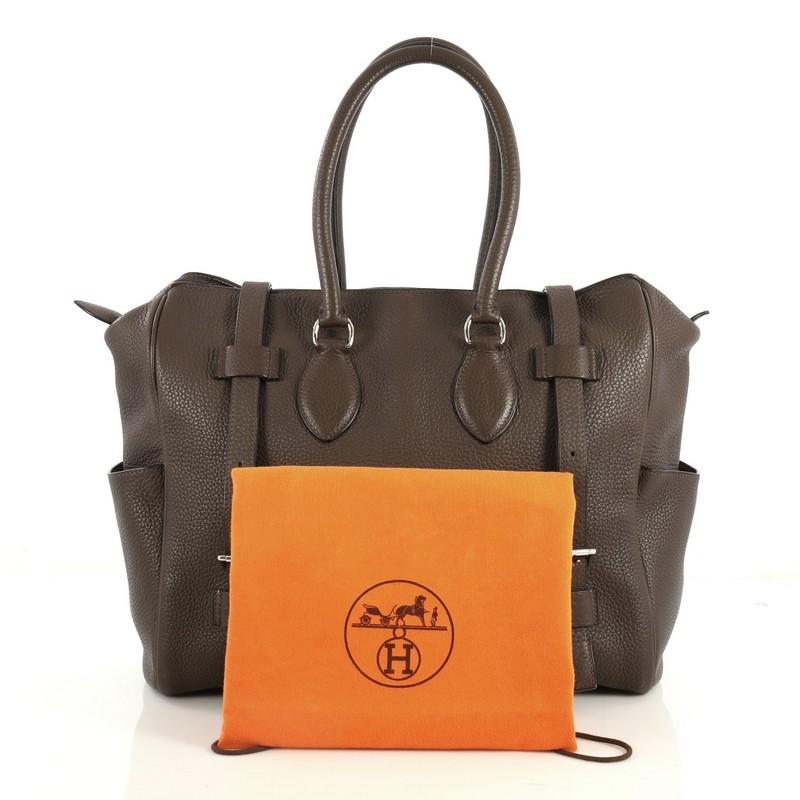 This Hermes Pursangle Handbag Leather 35, crafted from Chocolate brown Clemence leather, features dual rolled handles, exterior side slip pockets, buckle fastenings, and palladium hardware. Its zip closure opens to an Ecru neutral Toile Chevron