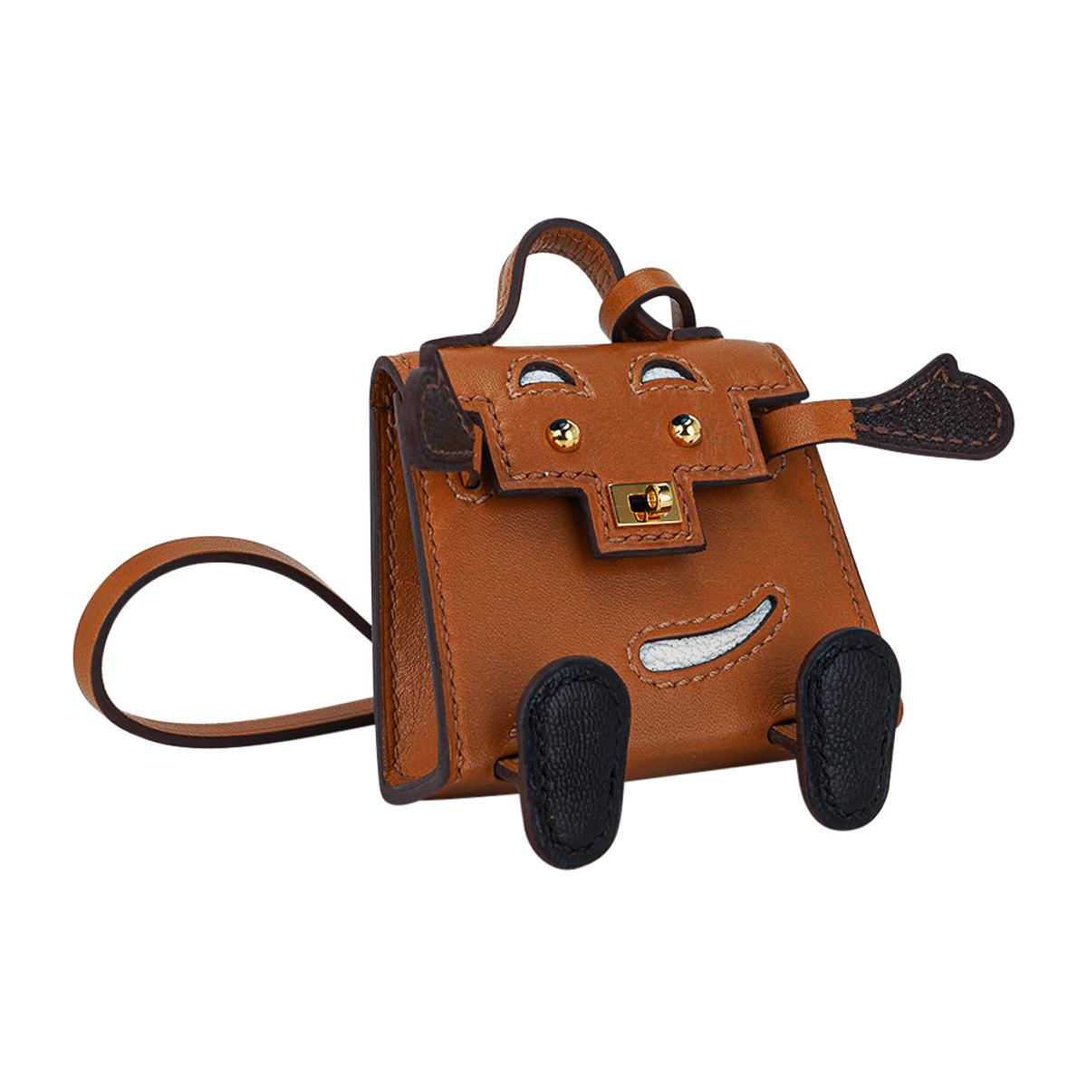 Mightychic offers a very rare limited edition Hermes Kelly Idole bag charm featured in  Sable, Havane, Black and Mushroom.
This playful Kelly Doll charm is created in Veau Butler and Chevre Mysore leathers.
Whimsical and delightful this fabulous