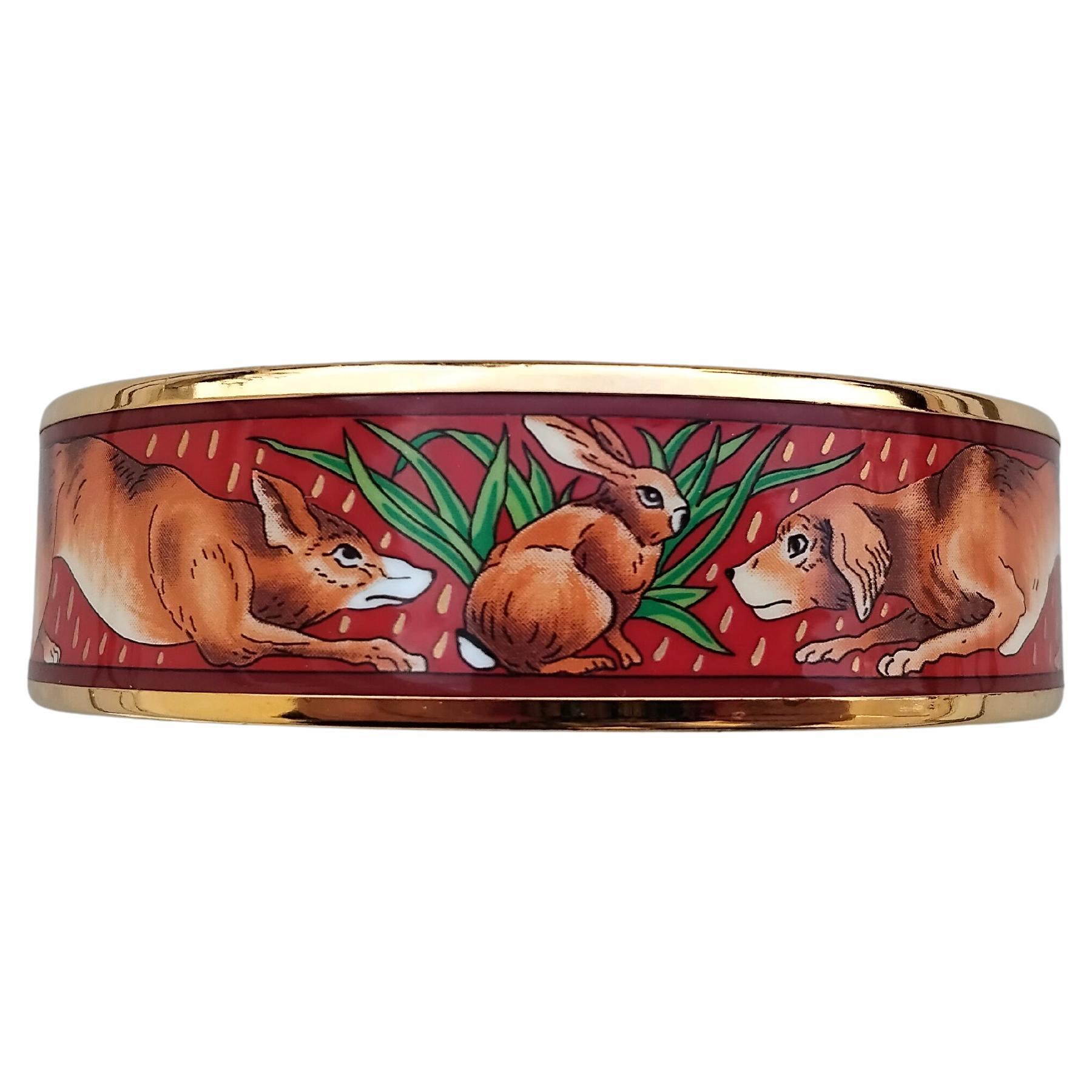 Mignon, rare et beau set de bracelets et boucles d'oreilles MQatching Hermès authentique

Le bracelet est imprimé deux fois du même motif : 2 chiens entourant un petit lapin posé devant une touffe d'herbe, le fond rouge foncé étant décoré de petites