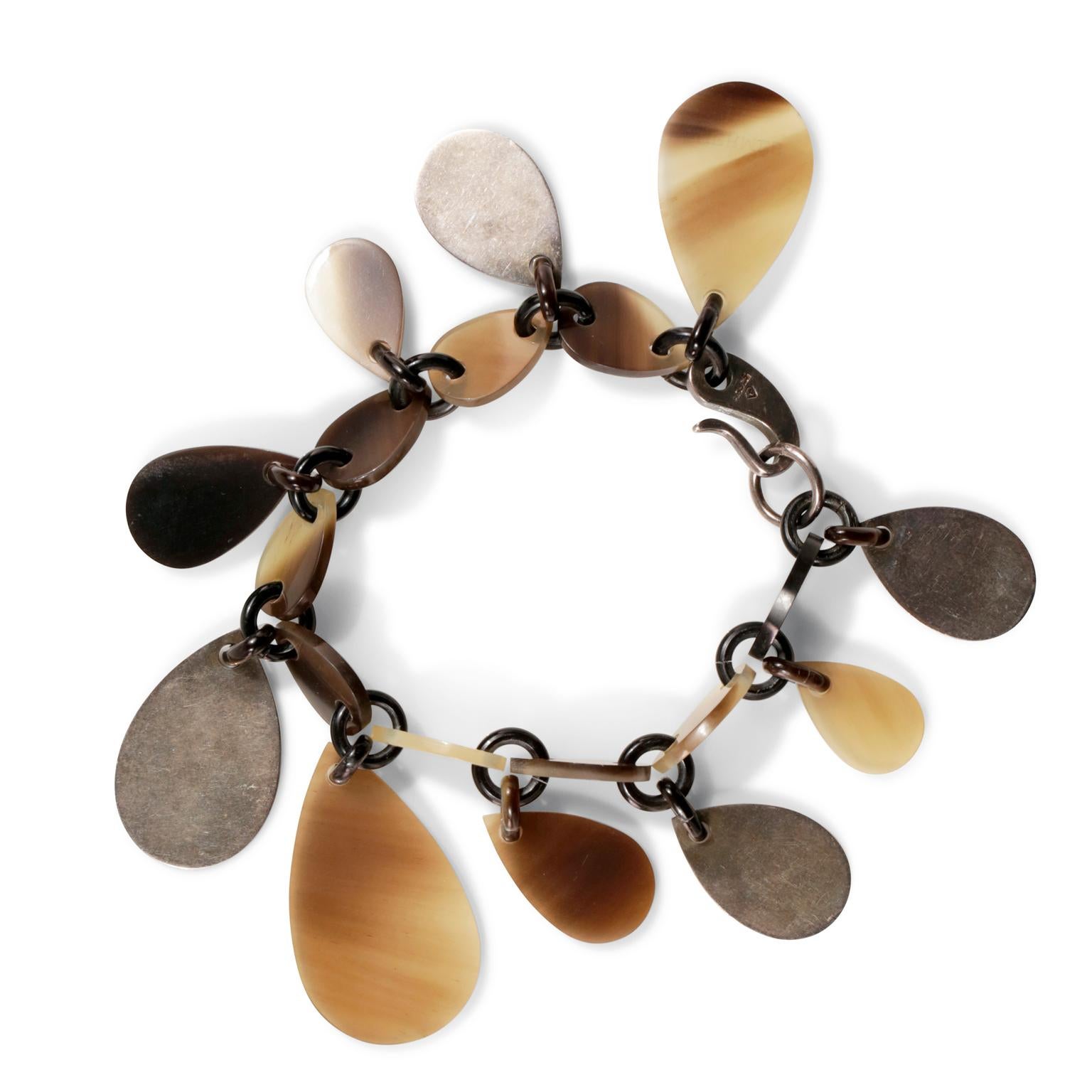 This authentic Hermès Raji Horn Bracelet is in excellent condition.  Neutral colored lacquered buffalo horn teardrop shaped charms dangle all the way around this natural bracelet.  Sterling silver hooked clasp. Box or pouch included.
