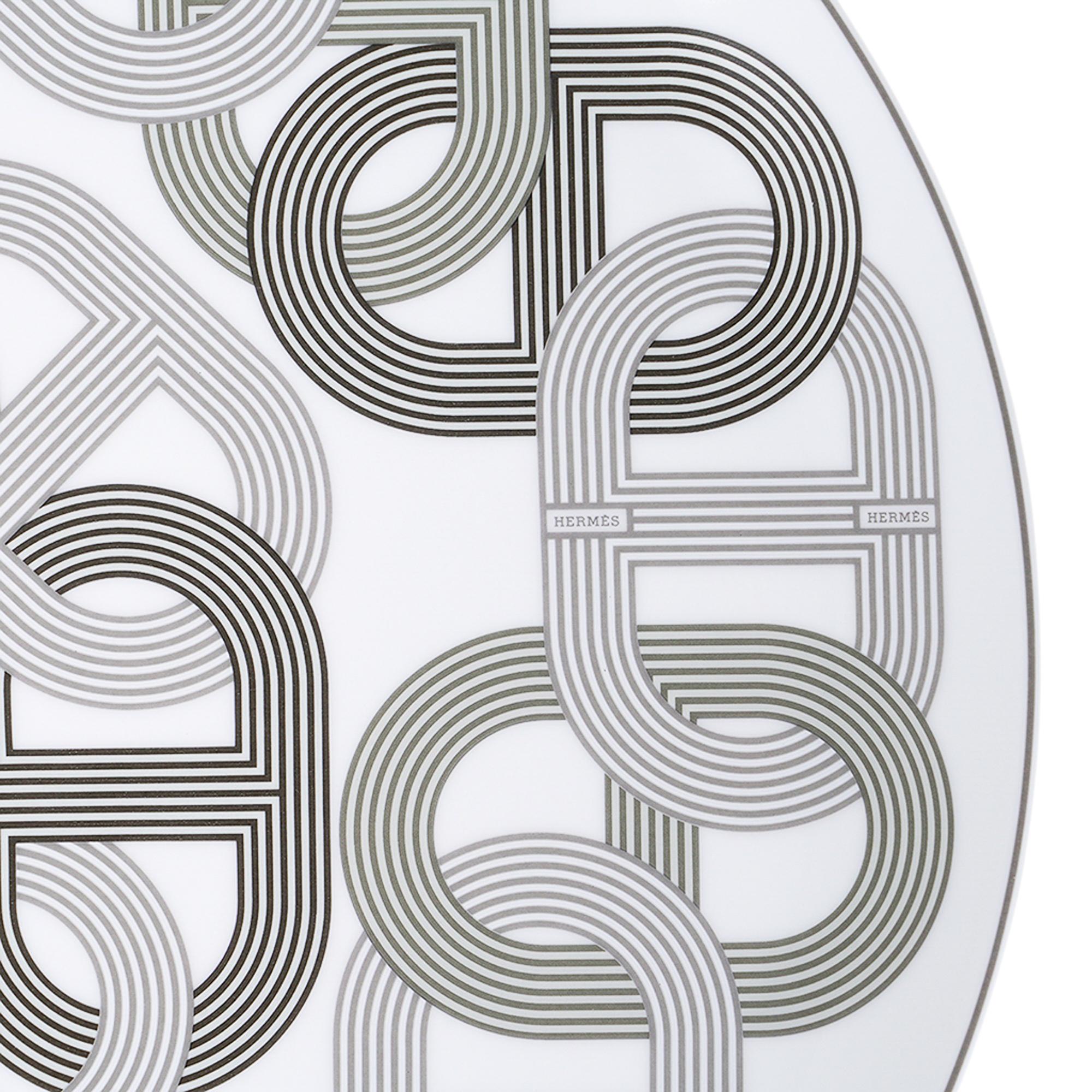 Mightychic offers an Hermes Rallye 24 Tart Platter featured in White.
The iconic Chaine D'Ancre motif creates the curves and straights of the racetrack.
The interwoven shapes are an infinite circuit created in black and gray.
Rallye 24 is