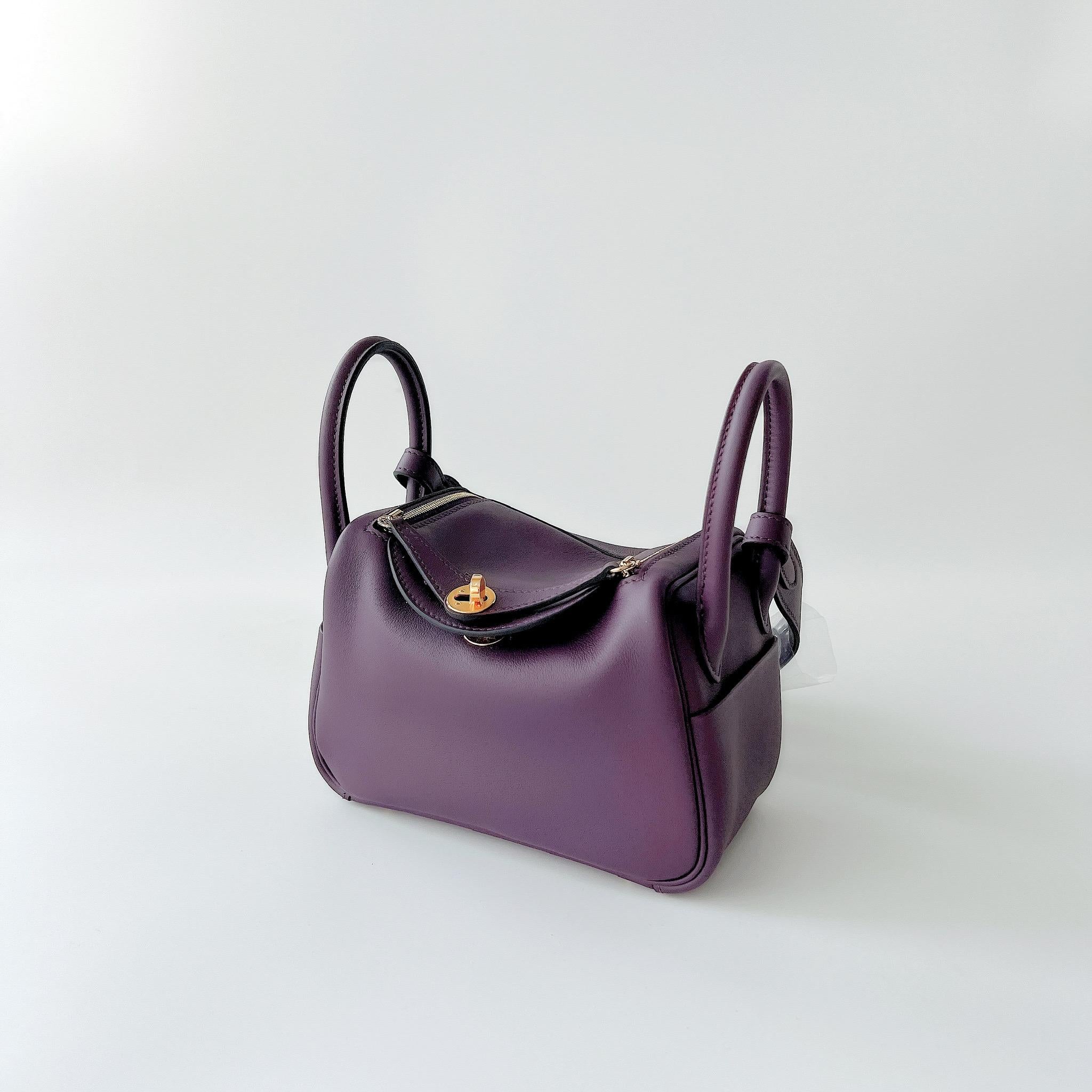 A perfect bag for the upcoming winter. This Hermes Mini Lindy comes the new colour way for Fall 2022, Cassis. Cassis is a warm dark purple colour and is contrasted with a Bleu Royal interior (New Colour for 2022). The Mini Lindy comes in a soft