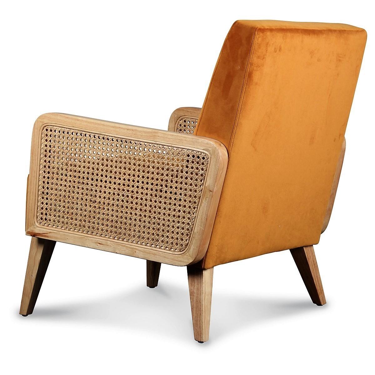 Handmade in France with a retro feel but a modern look -  this velvet upholstered, cane detailed armchair is distinguished by its vintage orange color and condensed design. 

The wide padded velvet seat gives it a soft and elegant feel while the