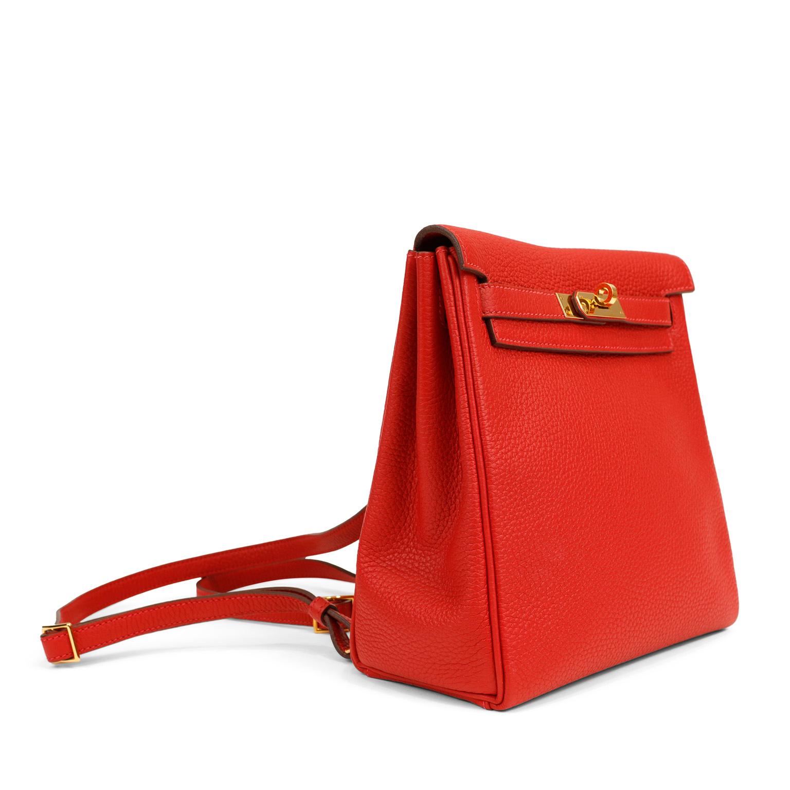 This authentic Hermès Red Clemence Kelly Backpack is in pristine condition.   The backpack silhouette relaxes the Kelly design elements in this casual hands free style.  
Lipstick red Clemence leather is textured and soft to the hand.  Made from the