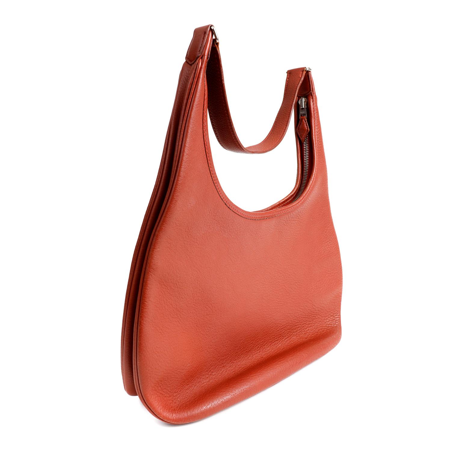 This authentic Hermès Rust Clemence Gao Shoulder Bag is in excellent condition. Simple and understated, this slim design is perfect for every day.
Textured and durable dark red Clemence leather with Palladium zippered top opening. Cream toile fabric