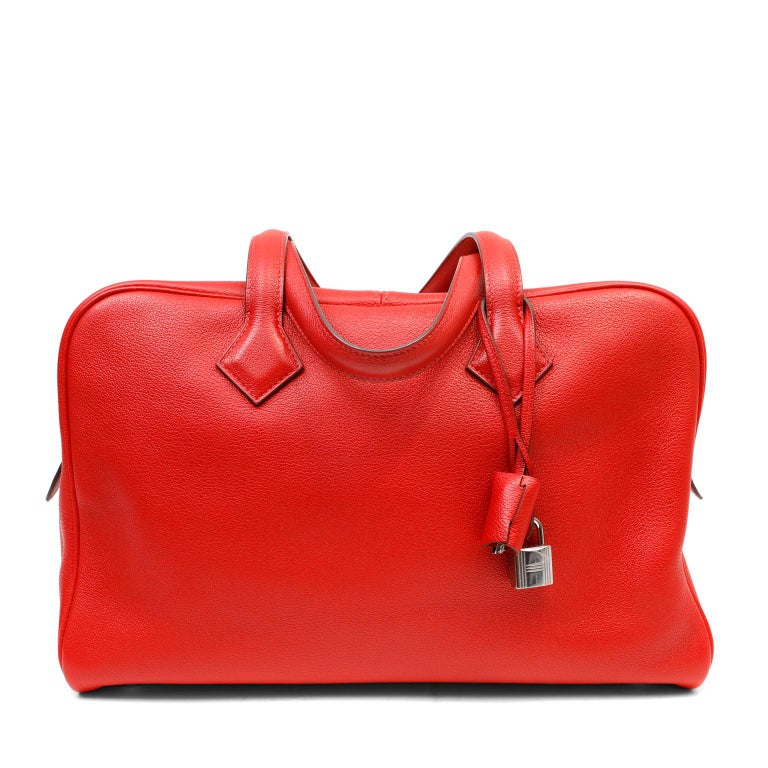 This authentic Hermès Red Clemence Victoria II Bag is in excellent plus condition.  The relaxed silhouette is roomy and soft to the hand in textured lipstick red Clemence leather.  Two-way double zip closure accesses the canvas interior.  Palladium