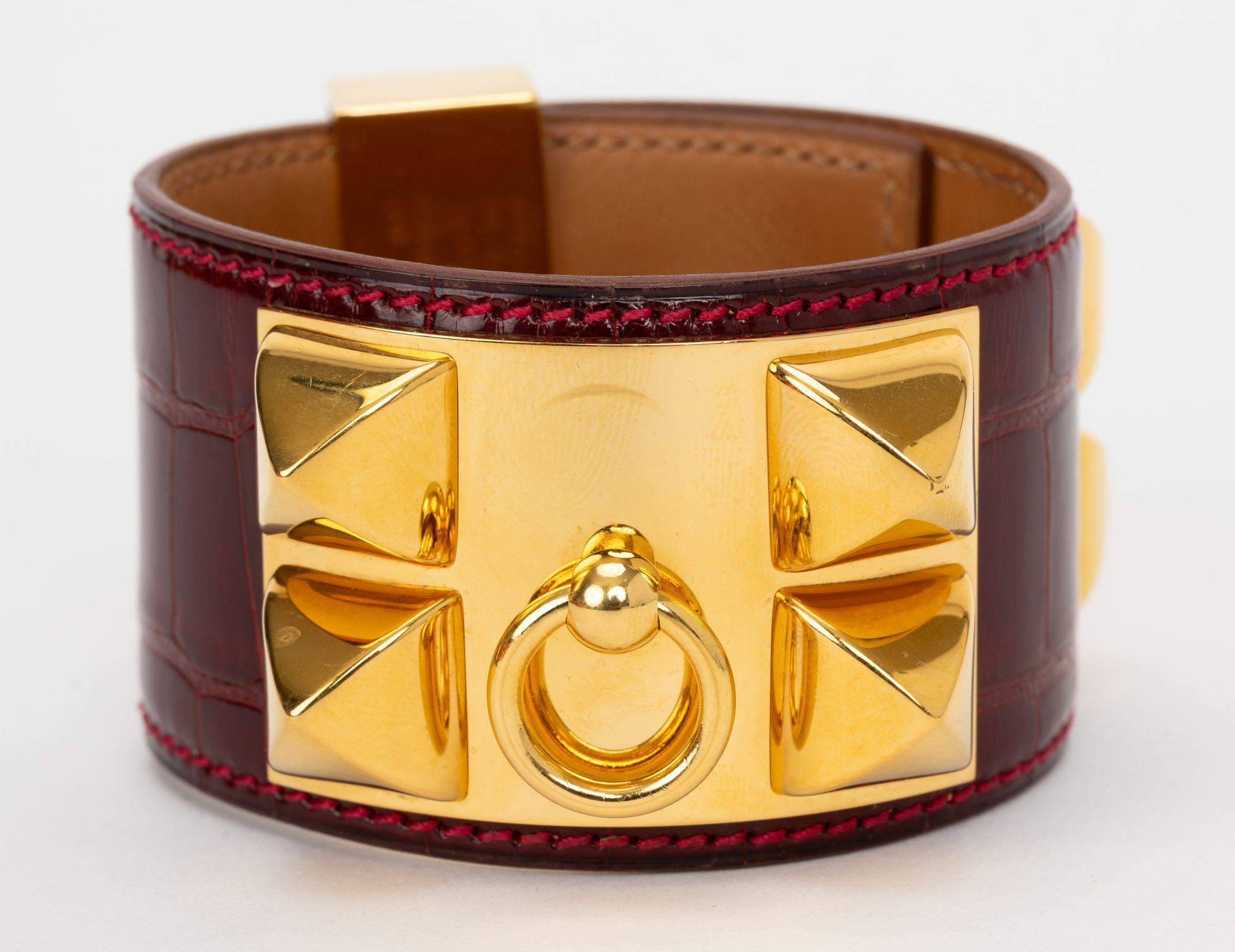 Il Collier De Chien di Hermès in alligatore rosso bordeaux e finiture dorate. Timbro con data F. Viene fornito con copertina e scatola originali. Non ci sono citazioni.