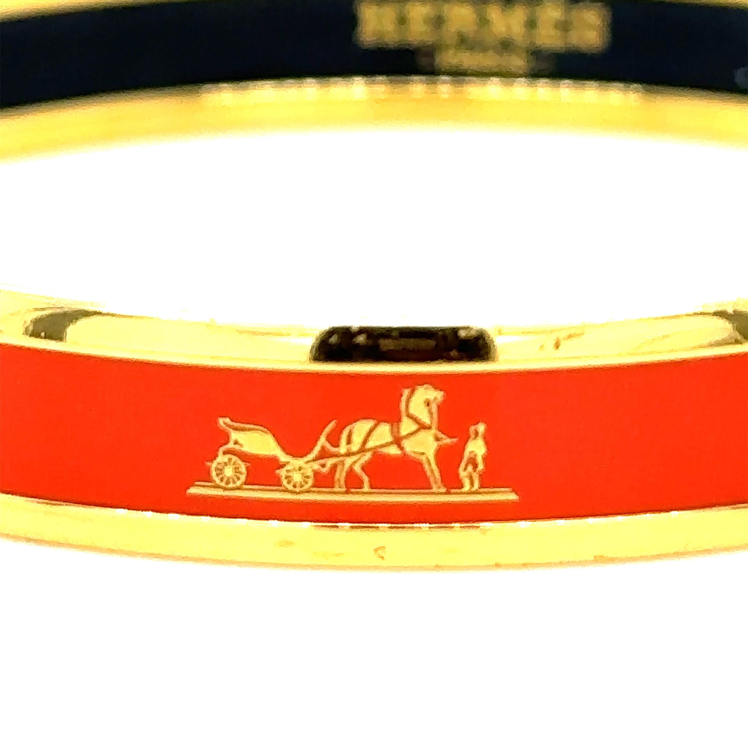 A Hermes Red Enamel Gold Plated Caleche Narrow Bangle Bracelet.

This narrow enamel bangle features gold plated trim with red enamel and a tiny signature horse and carriage design. Wear it along or with a stack of bangles for an instantly chic