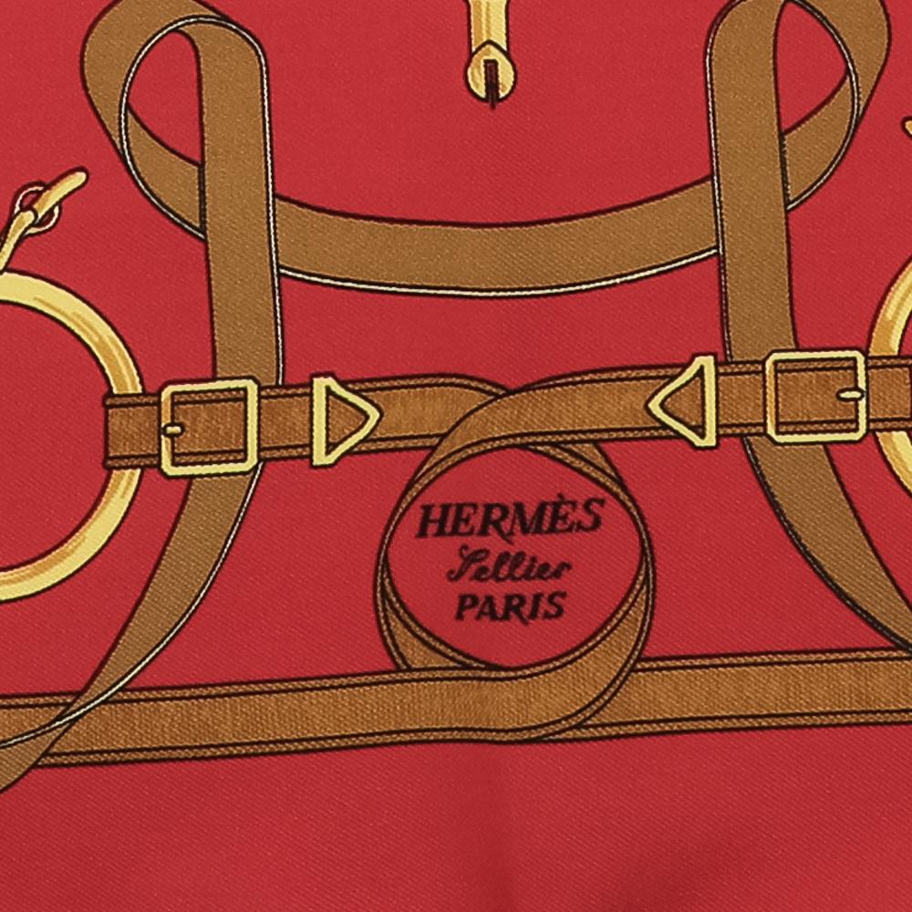 Rinfresca i tuoi outfit estivi accessoriandoli con questo bellissimo foulard della Maison Hermes. Realizzata in tessuto di seta rosso Eperon d'Or, questa sciarpa ha una silhouette squadrata di 41,5 cm x 41,5 cm. Questo foulard di Hermes sarà davvero