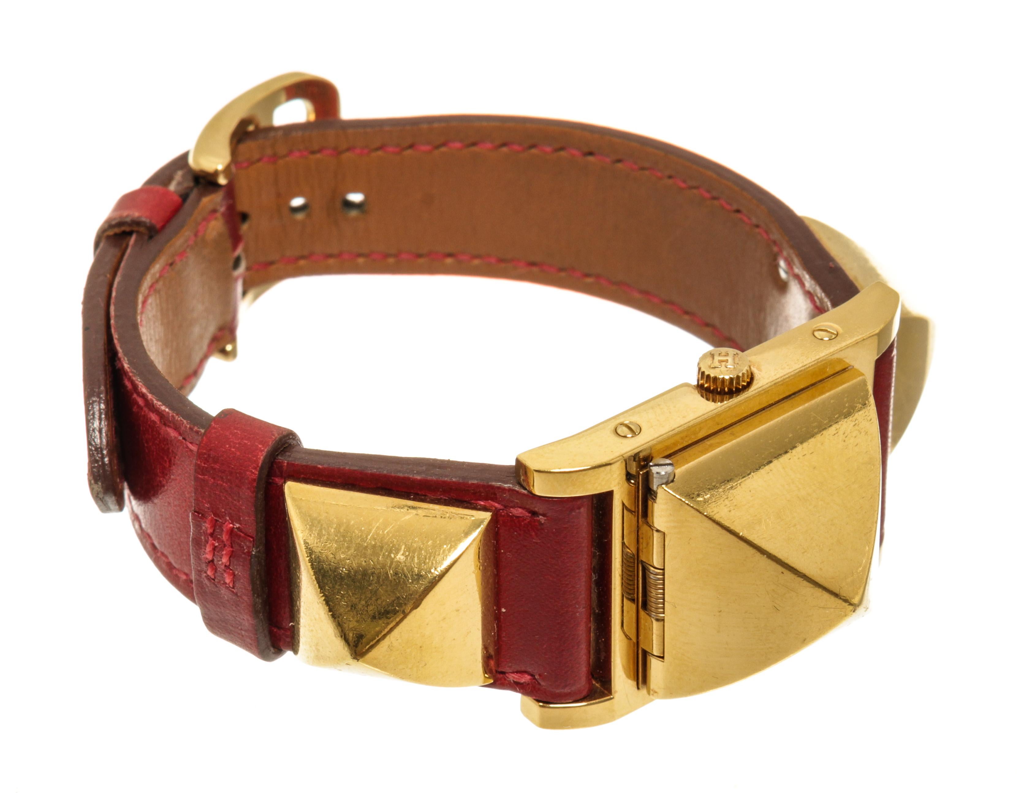 Hermes Rotvergoldete und lederne Medor Quarzuhr 23 mm mit quadratischem Zifferblatt, vergoldetem Leder, charakteristischem Clous-de-Paris-Nietenbesatz, Mineralglas, Krone mit Feststellvorrichtung.

79227MSC