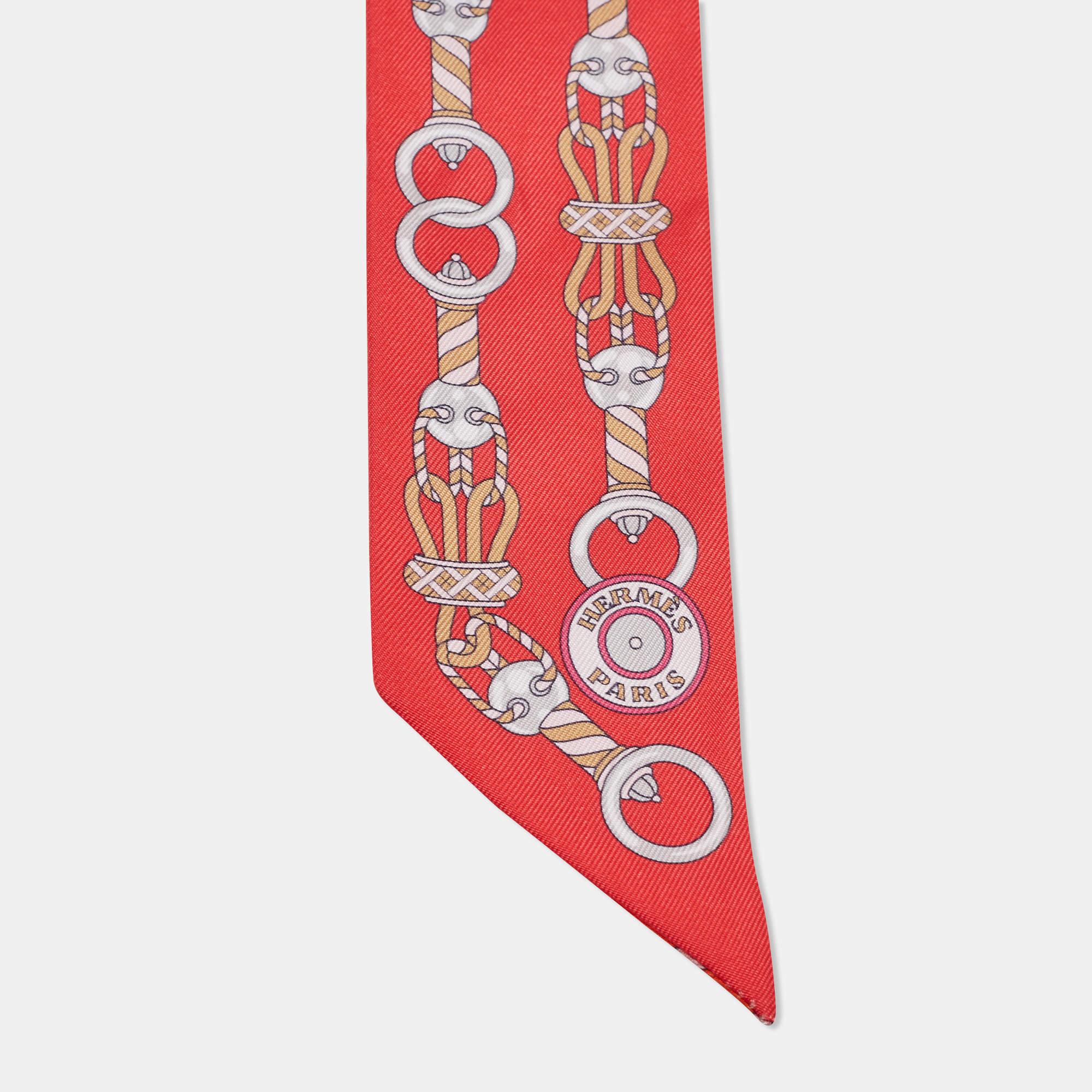 The Hermès twilly is a luxurious accessory crafted from sumptuous silk. Its vibrant red hue features a stunning equestrian-themed design, showcasing intricate bridles.

Includes: Original Box

