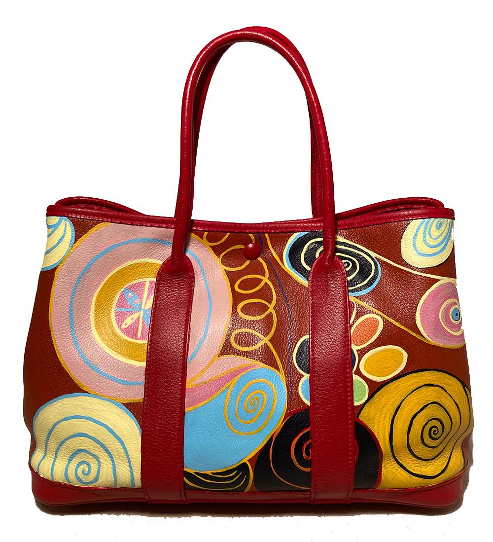 Hermes Red Leather Hand Painted Garden Party 30 in very good condition. Smooth red leather exterior with hand painted yellow, blue, pink, black green, and orange swirl and circle design along front and back. Deeper red painted handles and trim. Top