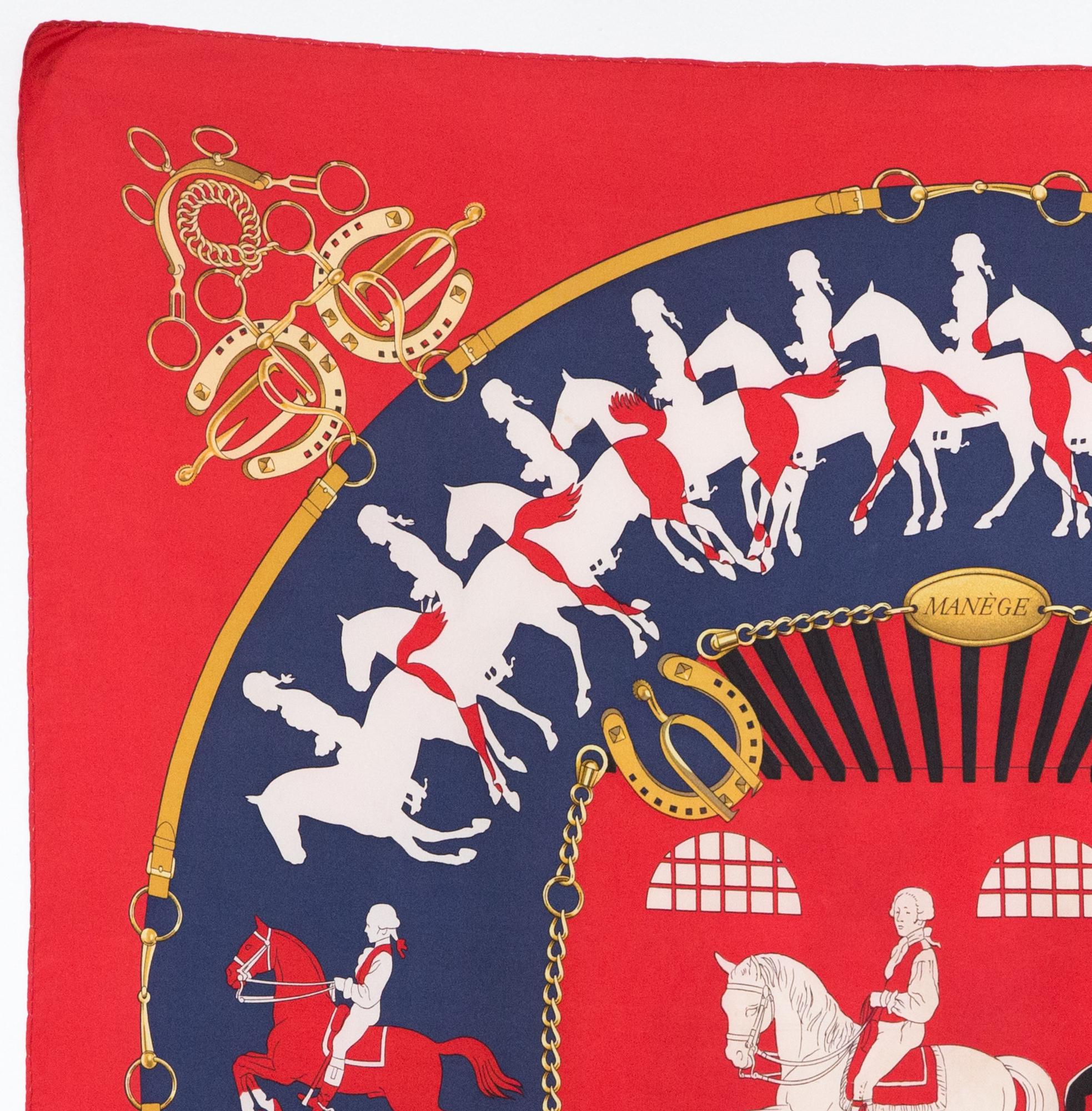 Hermes red silk scarf Manege by Philippe Ledoux featuring a red border and a Hermès signature. 
First edition in 1974
In good vintage condition. Made in France.
35,4in. (90cm)  X 35,4in. (90cm)
We guarantee you will receive this  iconic item as
