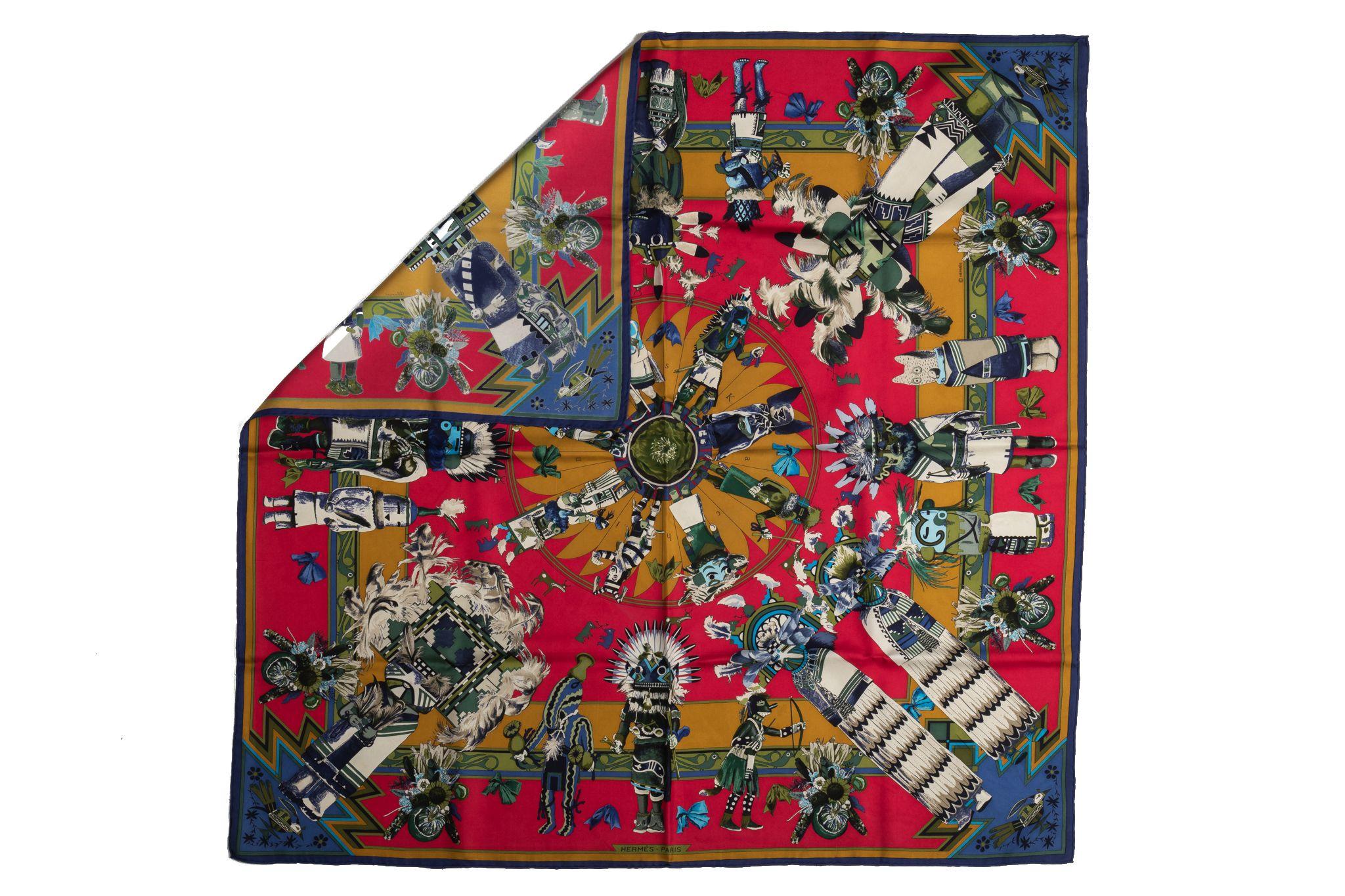 Hermès red and navy silk Kachinas scarf designed by Kermit Oliver. Hand-rolled edges. Original box included.
