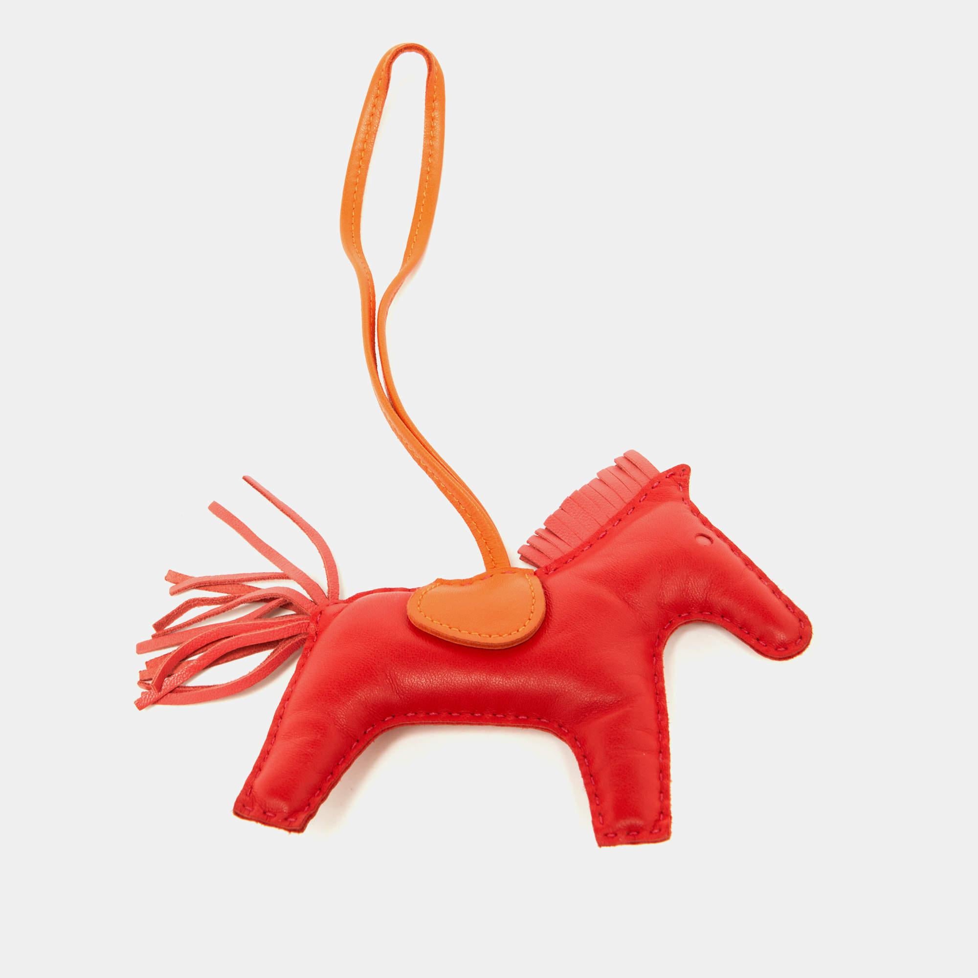 The Hermes Rodeo charm is a vibrant and stylish accessory. Made from high-quality leather, it features a rodeo-inspired design with fringed accents in striking red and orange hues. Perfect for adding a playful touch to any handbag or