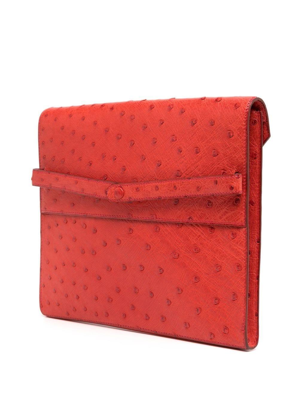 Die Red Ostrich Liddy Clutch Bag ist ein zeitloses und elegantes Modell mit minimalistischen, klaren Linien und Hermès' Vorliebe für leuchtende Farben. Diese seltene und begehrte Clutch aus genarbtem Leder in einem leuchtenden Rotton ist ein Muss in