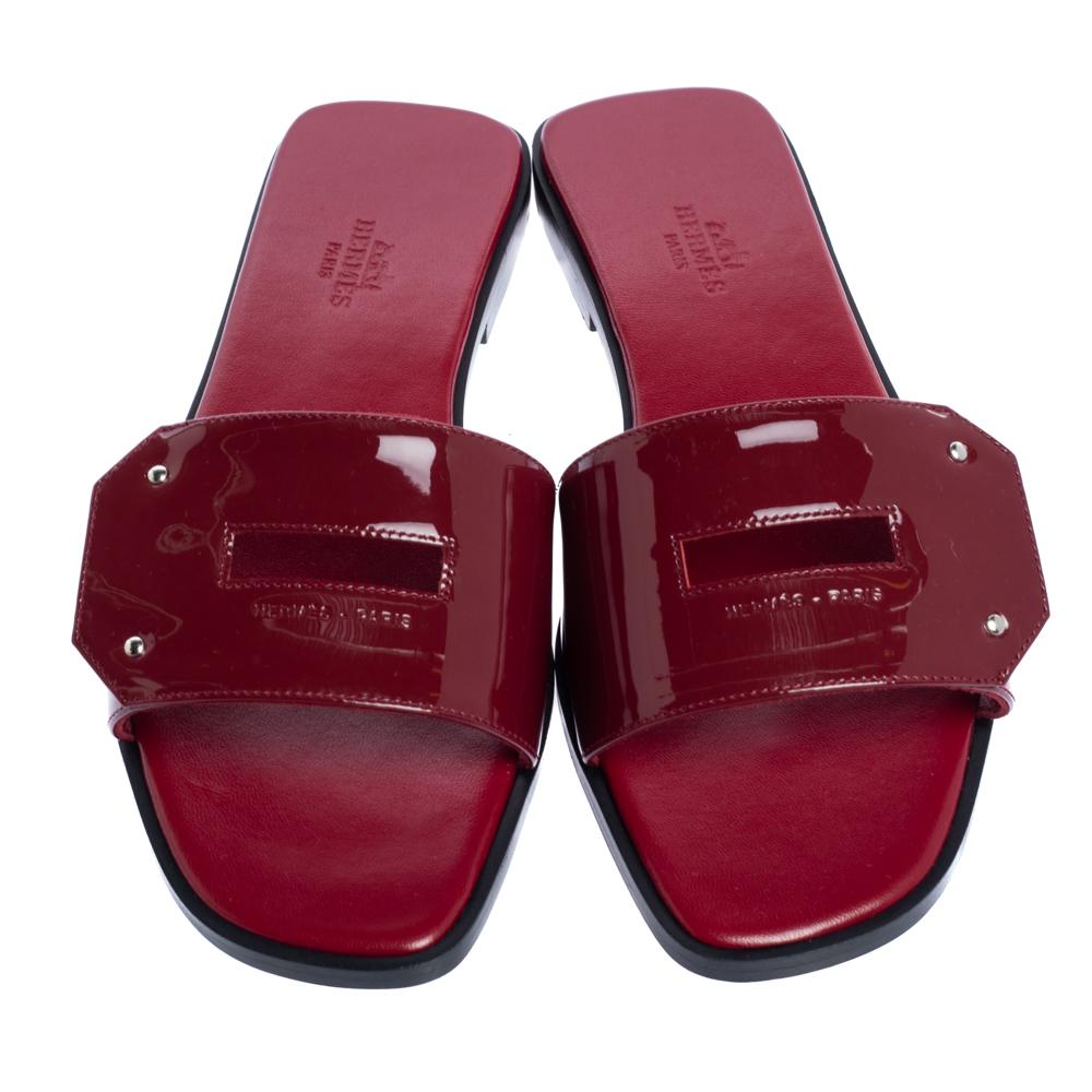 You'll find excuses to wear these slide sandals from Hermes that are all about comfort and effortless style! These sandals are crafted from patent leather with a cutout design on the vamps that resembles the iconic Kelly buckle. The pair is complete