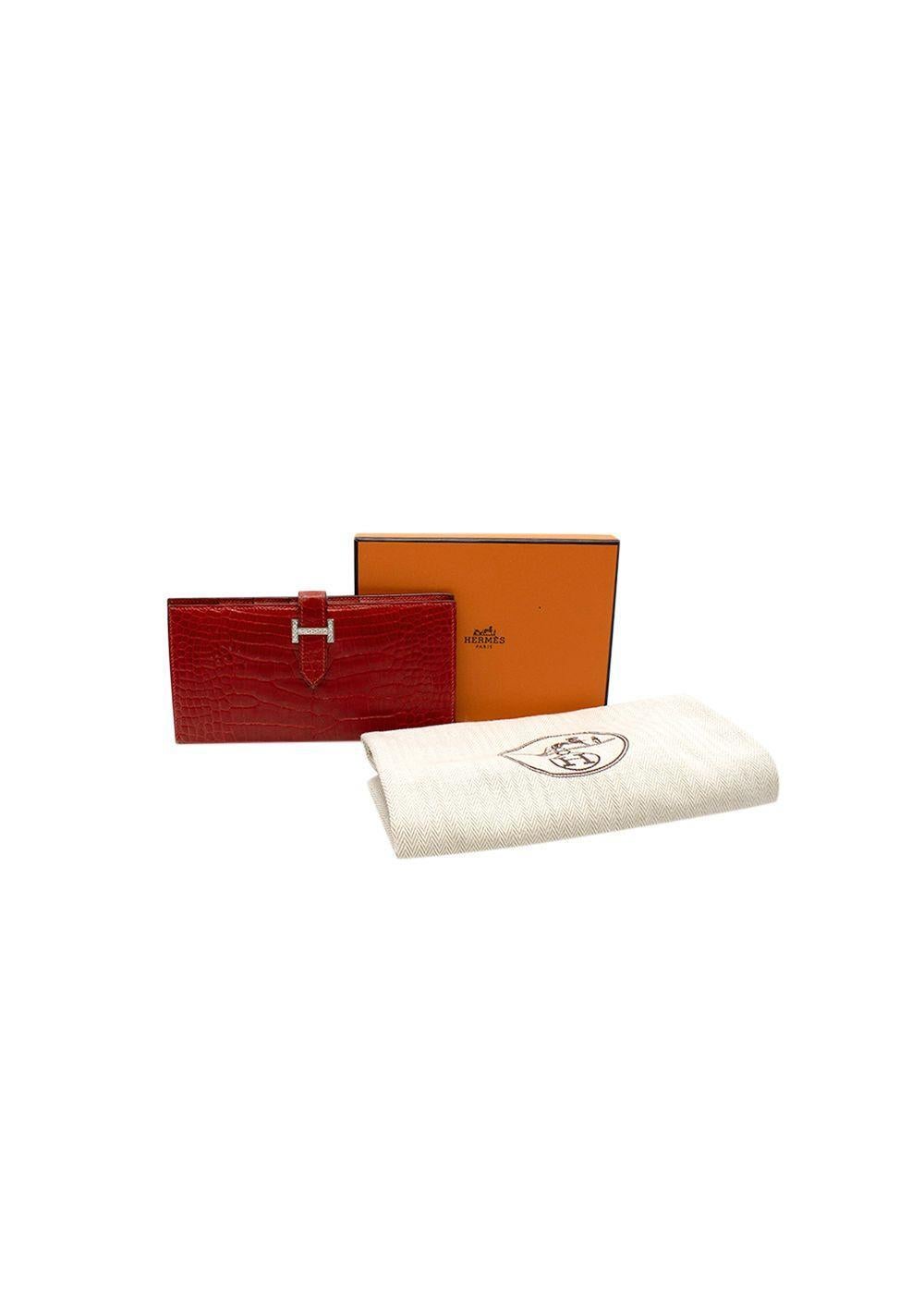 Hermes Red Shiny Crocodile Bearn Wallet in alligator crocodile, hardware is in 18 K white gold and diamond hardware, with 16 brilliant cut diamonds for a total diamond carat weight of 0.80 set in 6.50g of white gold.
Date stamp (J in square),
Year
