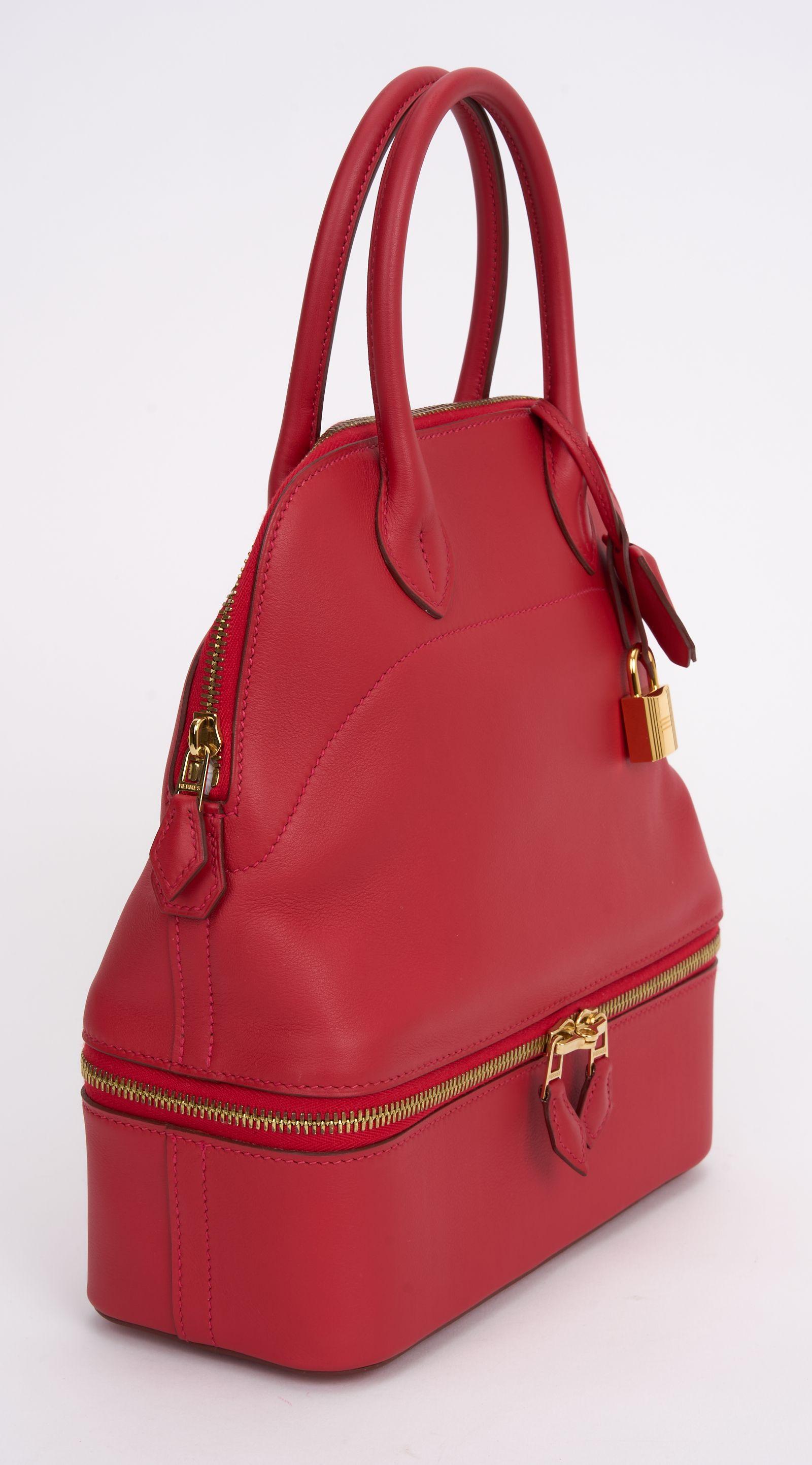 Questa borsa Bolide Secret con Swift in pelle Rouge Swift, hardware in palladio, finiture in pelle Milo, manici arrotolati e tracolla singola L'interno è foderato in pelle e presenta una tasca interna singola con chiusura a zip nella parte