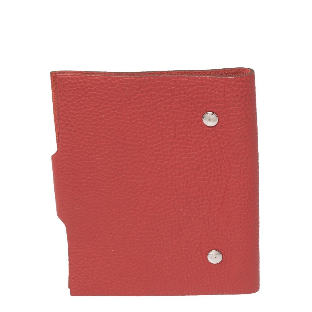 This Hermes Ulysse agenda cover will instantly add style and charm to your favorite notebook. It has been crafted from red Togo leather and comes with a snap fastener. Carry this to work or college for a statement-making look.
