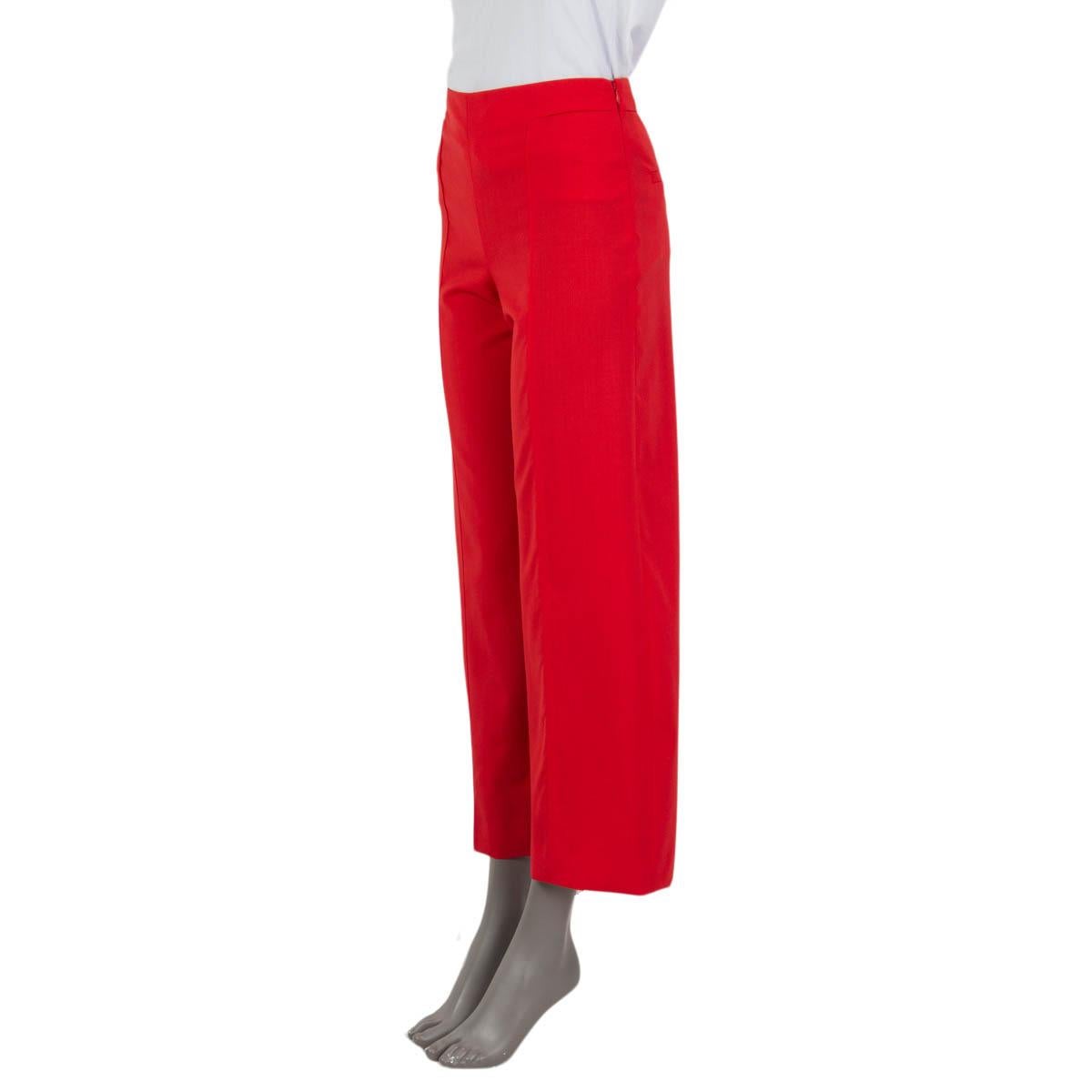 100% authentic Hermès wide leg suit pants in red virgin wool (100%). Feature two slit pockets on the front and two sewn shut slit pockets at the back. Open with a concealed zipper and a button on the side. Semi-lined in red viscose (88%) and