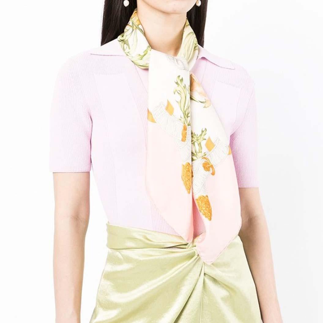 Inspired by Queen Elizabeth II, this beautiful pre-owned silk scarf was designed by Leila Menchari in 1972.  This feminine blush pink scarf depicts a beautiful bouquet of flowers, held together by a light blue ribbon with the motif 'Regina'. 