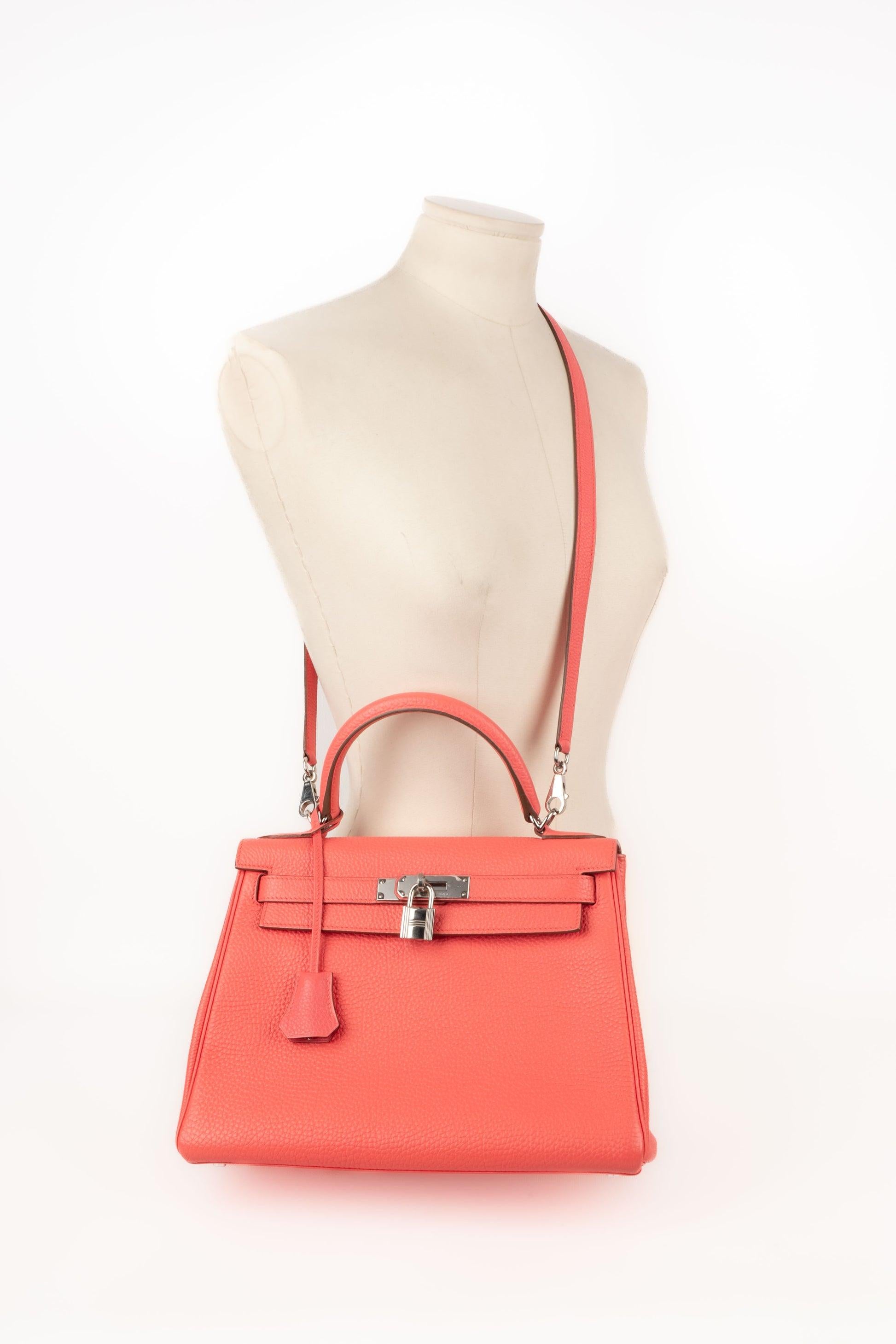 Hermès - (Made in France) 28cm Retourne Kelly bag made of Jaipur pink Clemence young bull leather, with palladium-plated silvery metal fastener and ties, handle. Keys under a tiny leather cloche, padlock, and a removable crossbody strap. 2013
