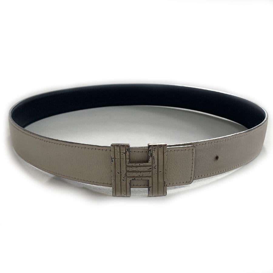 Iconic HERMES reversible belt in off-white and black color. Striated H buckle in silver metal. This belt, very popular because of its buckle, will fill your wardrobe. Its small width will allow you to wear it even on trousers with small
