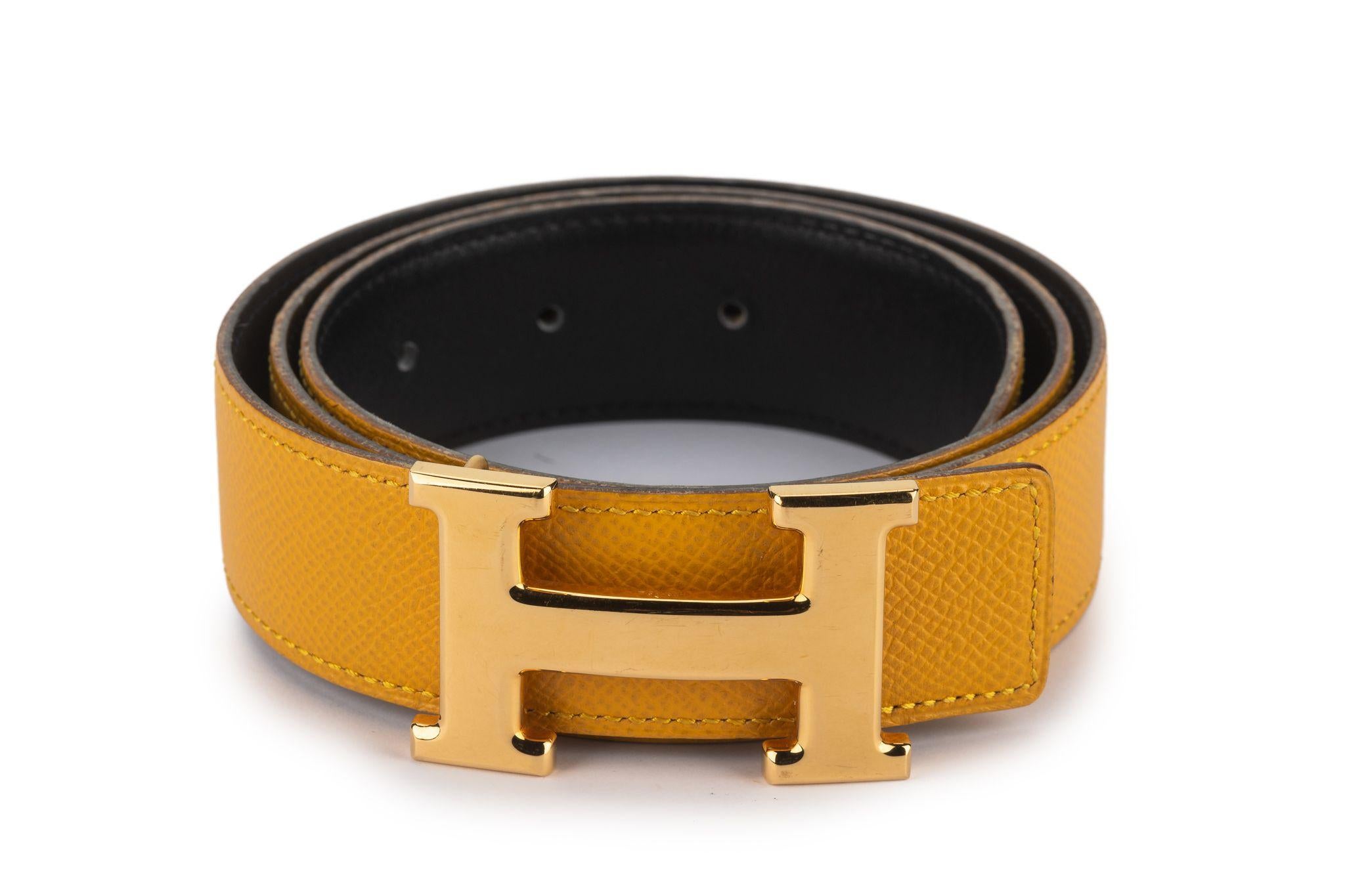 Questa cintura H. H. è realizzata in pelle reversibile con un lato in nero e il retro in pelle gialla. La cintura è completata da una fibbia H. H. placcata in oro giallo lucido. Usura minima. Viene fornito con la copertina originale.