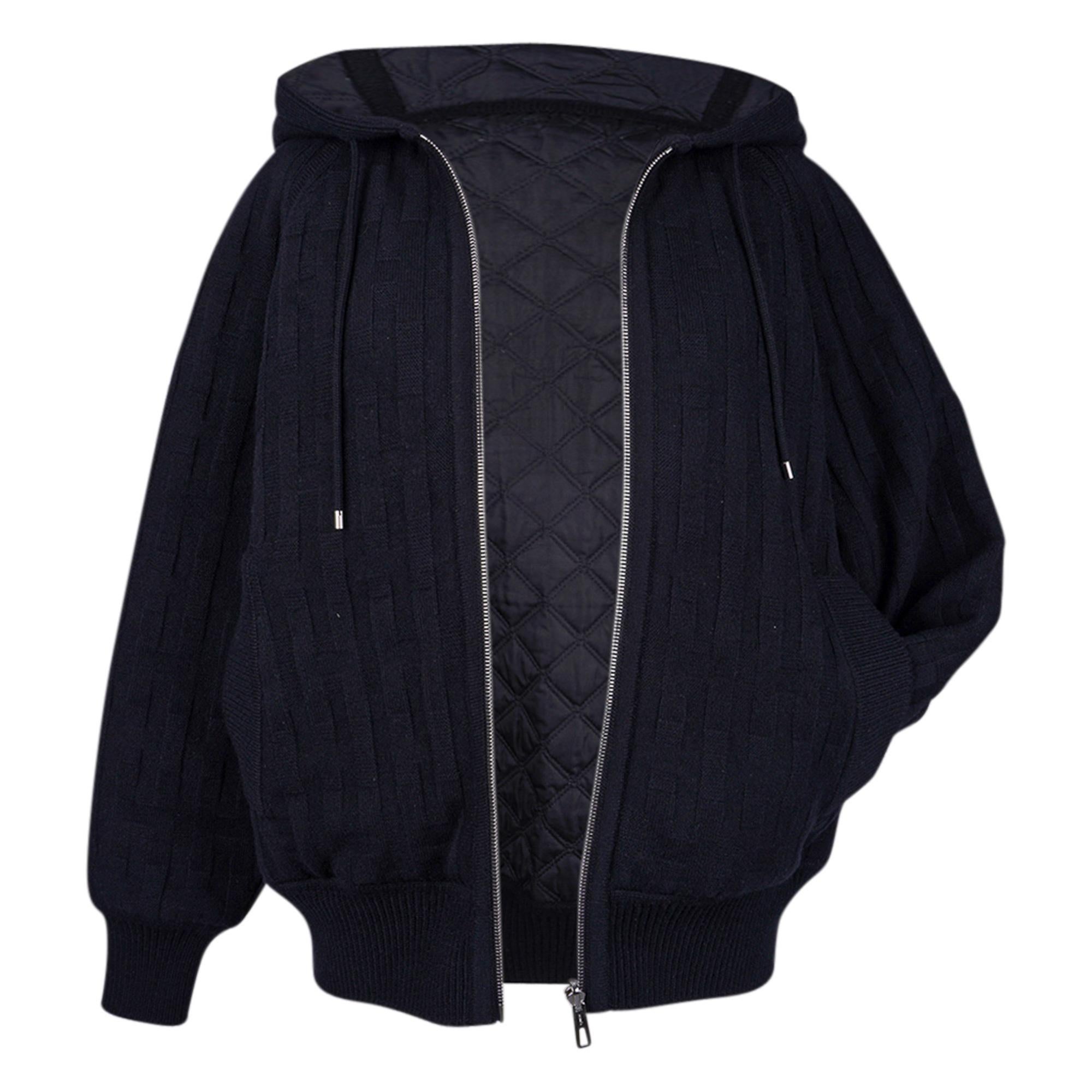 Mightychic offers an Hermès Reversible Zip Cardigan featured in Black on Black.
Warm with hood and quilted cotton, wool and plume canvas.
Virgin wool with Losanges and H motifs.
Reverses to wadded brown quilted side with ribbed waist and