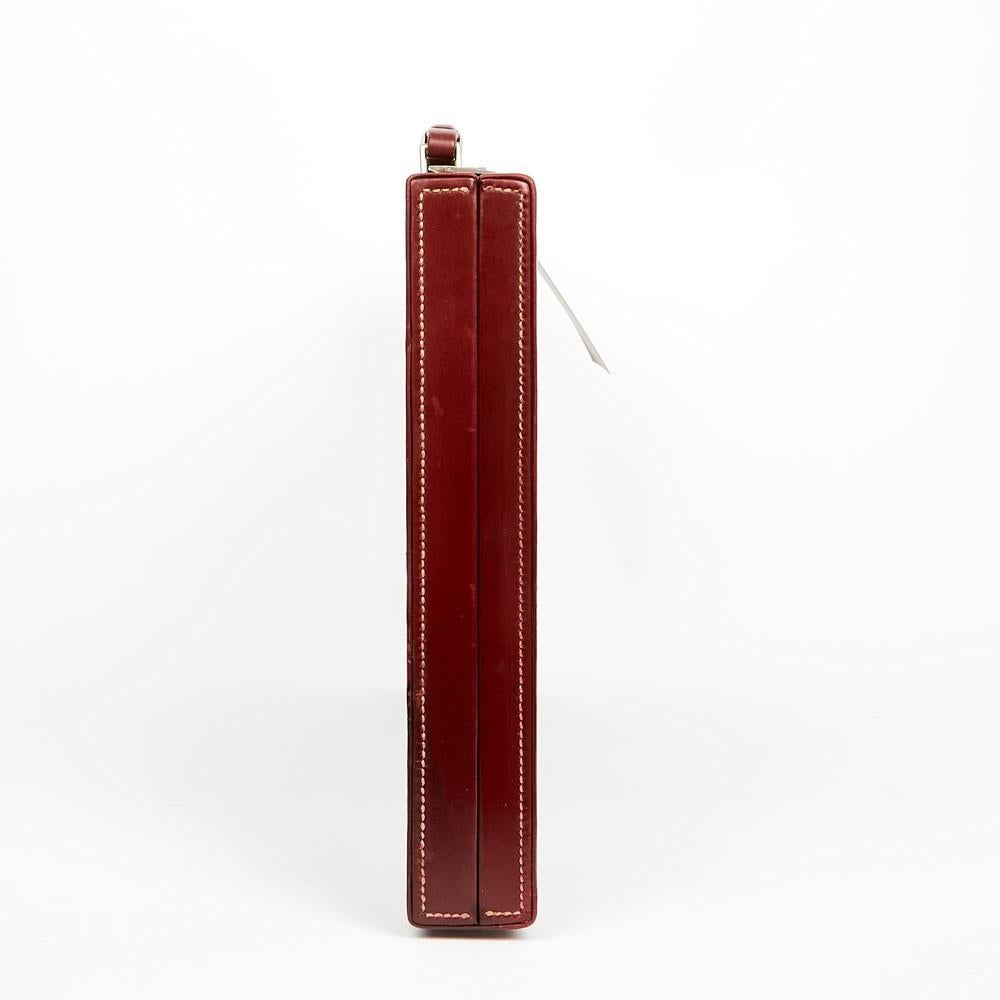 This Hermes vintage vanity case is made of smooth red box leather, with initials M.W.G engraved on the top, and it closes by two points. We can see some scratches on the front and back of the handle but its general condition is very good. The inner