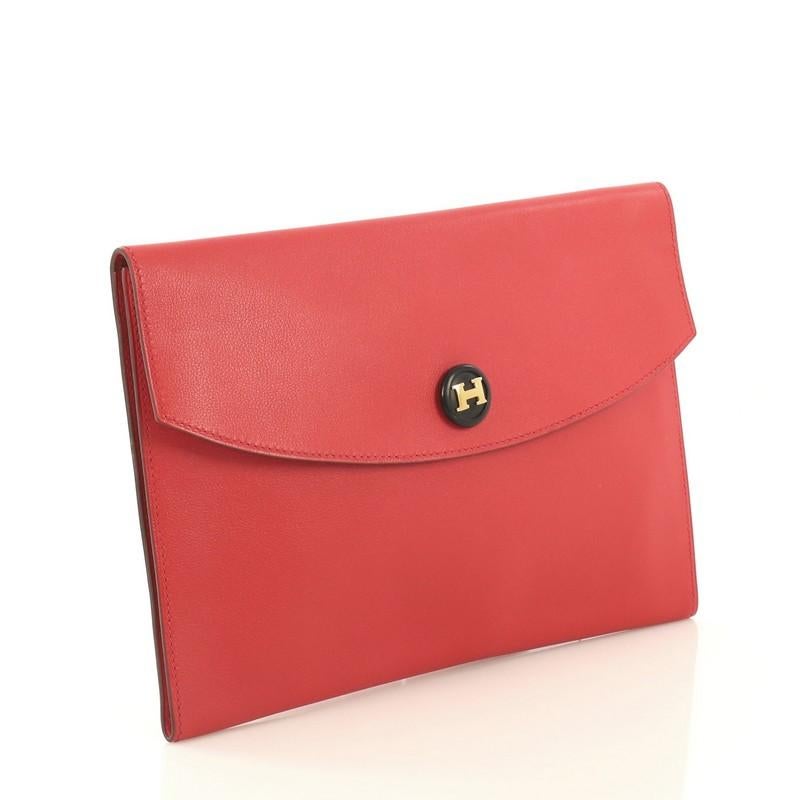 This Hermes Rio Clutch Leather PM, crafted from Rouge Vif red Gulliver leather, features logo embellished snap button and gold hardware. Its snap button closure opens to a Rouge Vif red Gulliver leather interior. Date stamp reads: B Square (1998).
