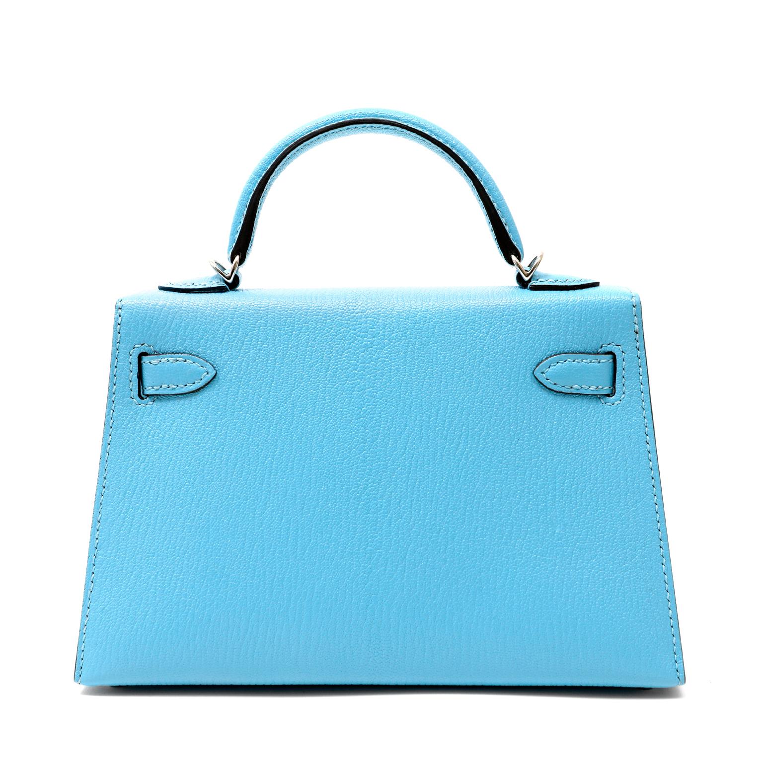 This authentic Hermès Robin's Egg Blue Chevre Mini Kelly is in pristine condition with the protective plastic intact on the hardware.  Petite and feminine, the crossbody Kelly is very rare in the 20 cm silhouette.
Striking Tiffany blue chevre