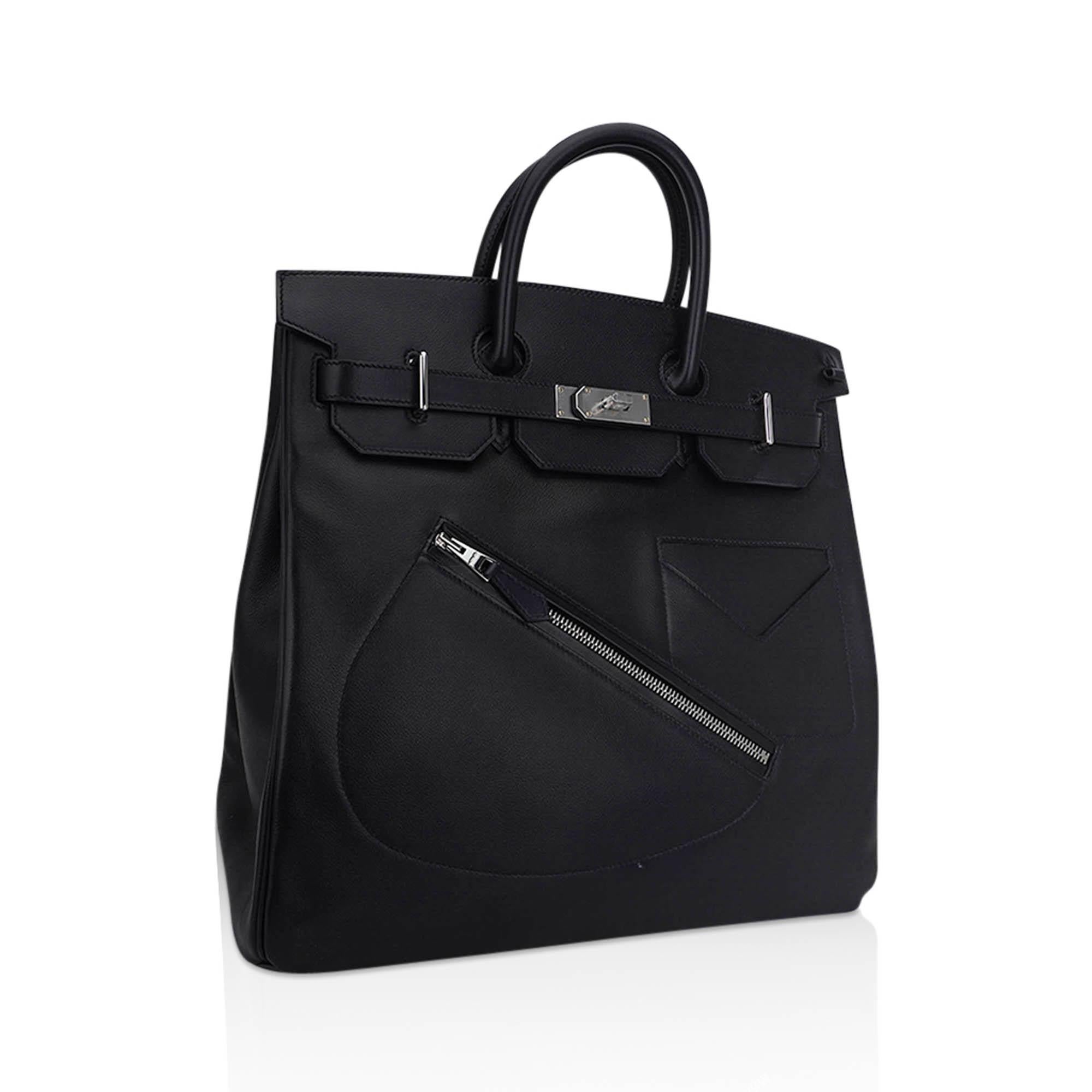 Mightychic offers an Hermes limited edition HAC Rock Birkin 40 (Haut a Courroies) bag featured in Black and Volupto leather.
The bag features a diagonal saddle shaped zippered pocket in front, tonal stitching and double rolled handles.
Inside the