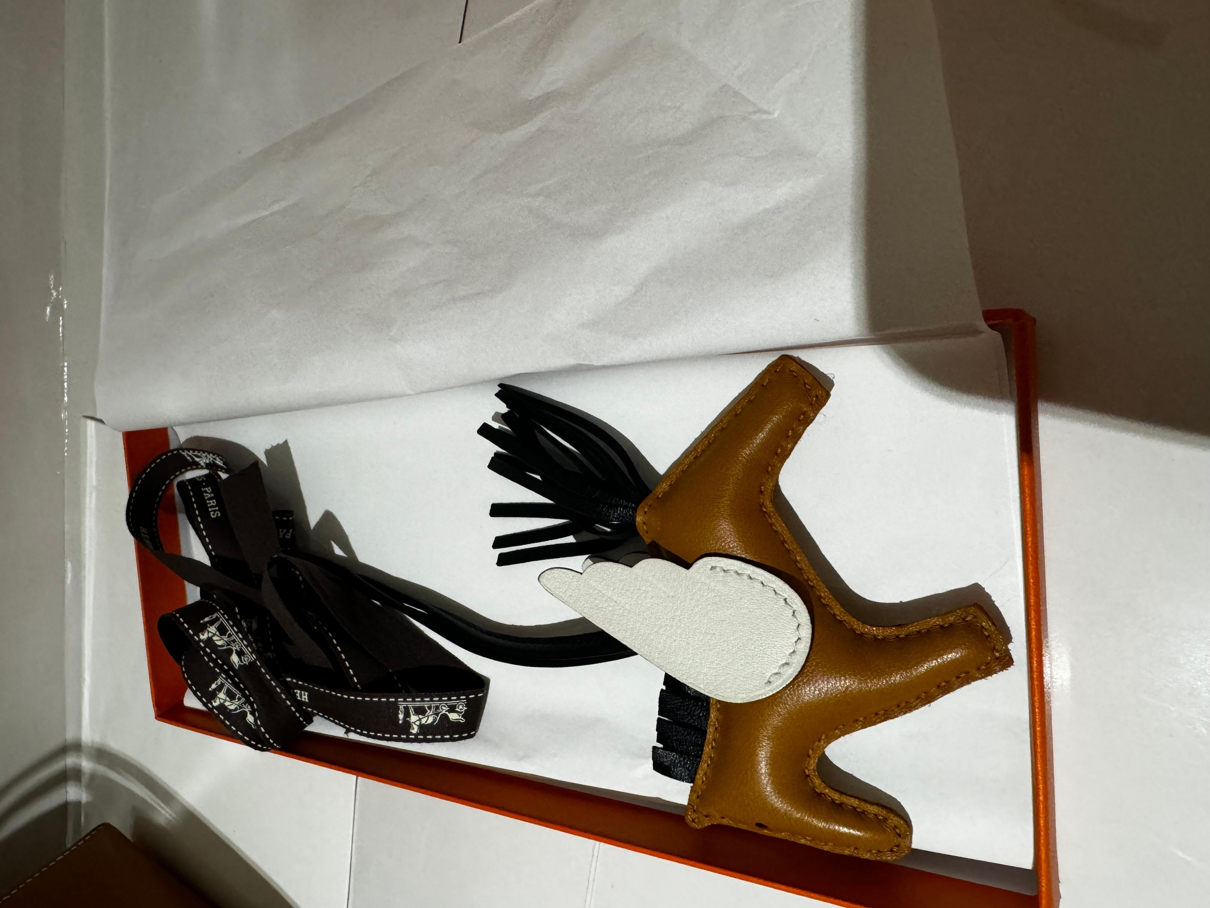 Hermès Rodeo Pegase Charm PM in Sesame, Black and Nata Milo Lambskin and Swift. 

Comes with box and ribbon, 2023

Dimensions

Height: 3.15 inches / 8 cm
Width: 3.94 inches / 10 cm
Depth: 0.79 inches / 2 cm
Handle Drop: 6.3 inches / 16 cm