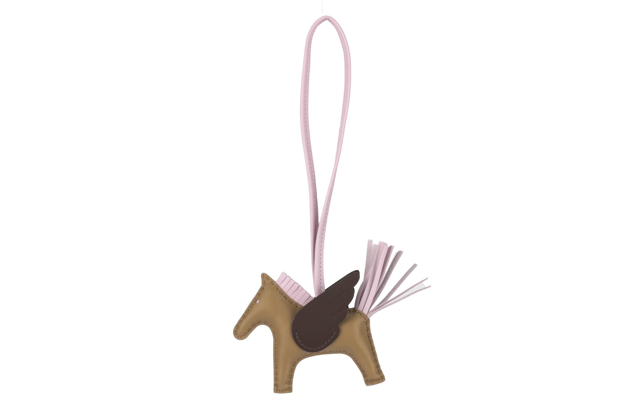 The Hermès Rodeo Pegasus charm in lambskin alezan , craie and mauve will complement any bag making it fun and unique. Comes with original box and ribbon. Brand new in unused condition.