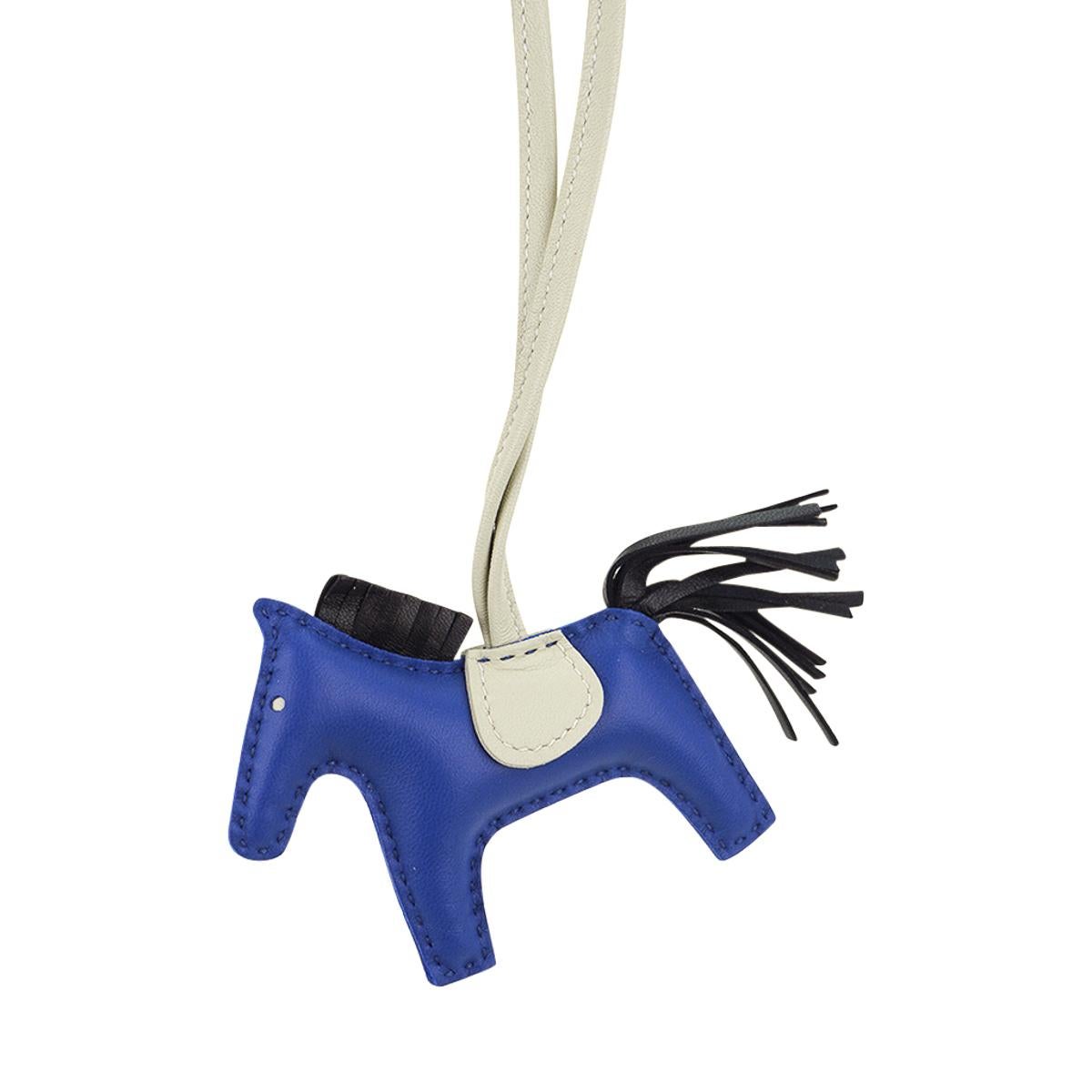 Mightychic offers an Hermes PM Rodeo bag charm featured in Blue de France, Craie and Black.
Charming and playful she easily adorns a myriad bag colours in your fabulous collection.
Skin is Milo lambskin.
Signature HERMES PARIS MADE IN FRANCE is