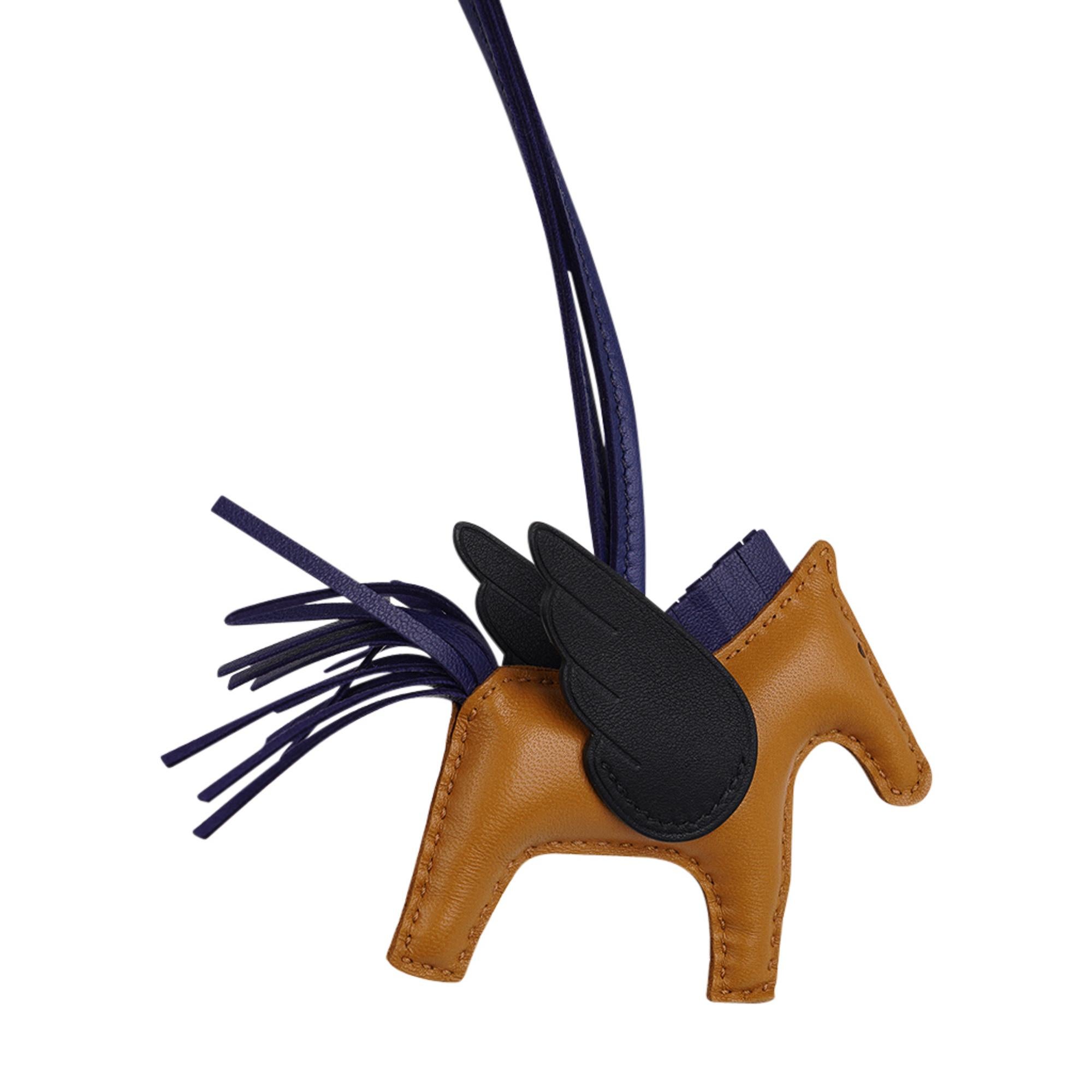 Mightychic offers an Hermes Pegase Rodeo PM bag charm featured in Sesame, Black and Bleu Saphir. (Blue Sapphire).
Charming and playful she easily adorns a myriad bag colours in your fabulous collection. 
Leather is lambskin Milo.
Signature HERMES