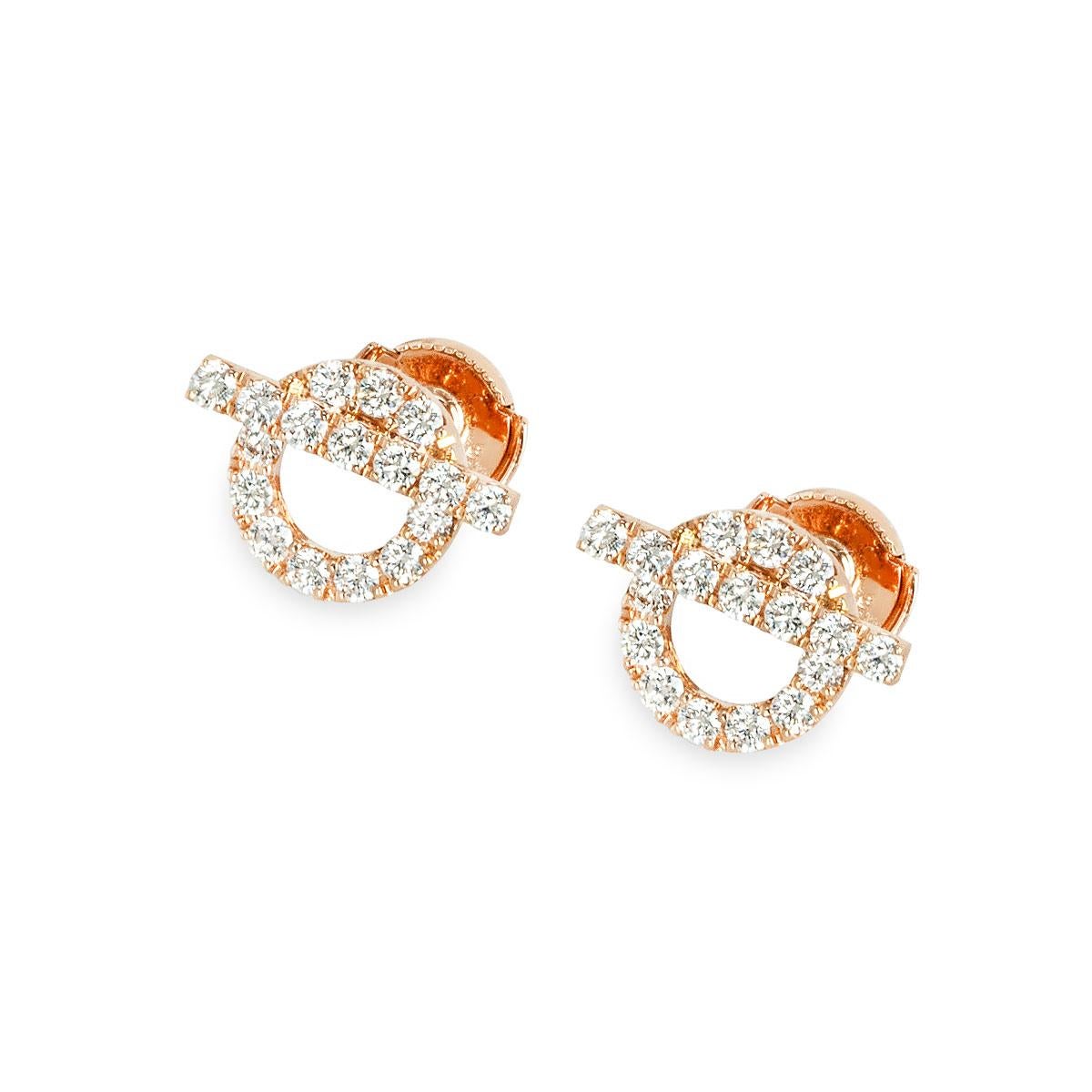 A stunning pair of 18k rose gold diamond earrings by Hermes from the Finesse collection. The earrings feature a circular motif with a bar across it set with pave round brilliant cut diamonds. Each set with 17 round brilliant cut diamonds, a total of