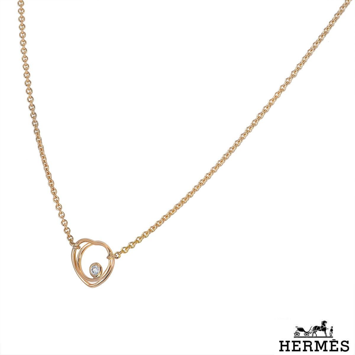 An 18k rose gold diamond necklace by Hermes from the Vertige Couer collection. The necklace features an openwork heart motif with a single round brilliant cut diamond. The diamond has a total weight of 0.05ct. The necklace has an adjustable length