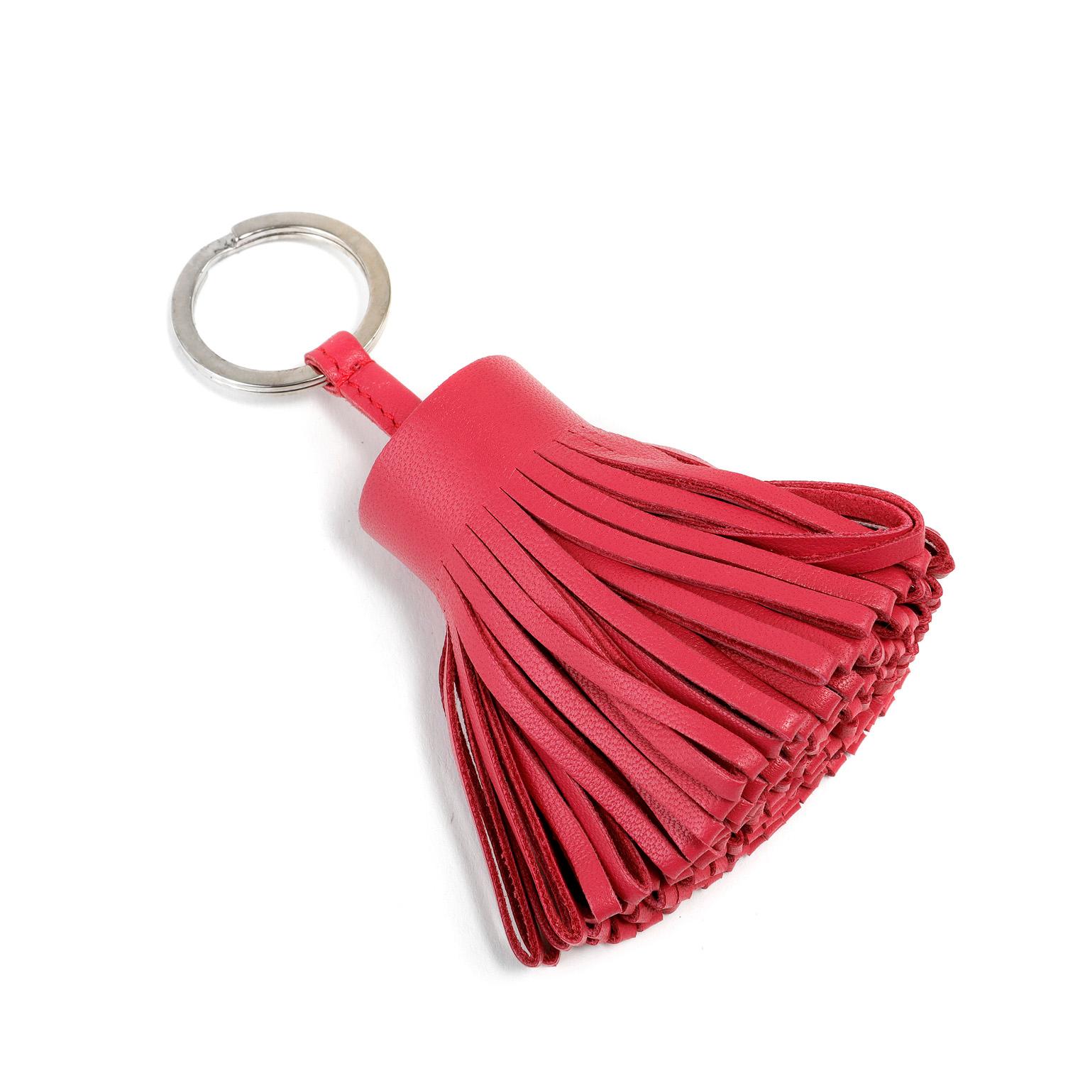 Cet authentique porte-clés Hermès en cuir rose à pompon est en parfait état.  Portefeuille à large pompon en cuir rose relié à un anneau de couleur argentée.  Transportez vos clés avec style.

PBF 11441